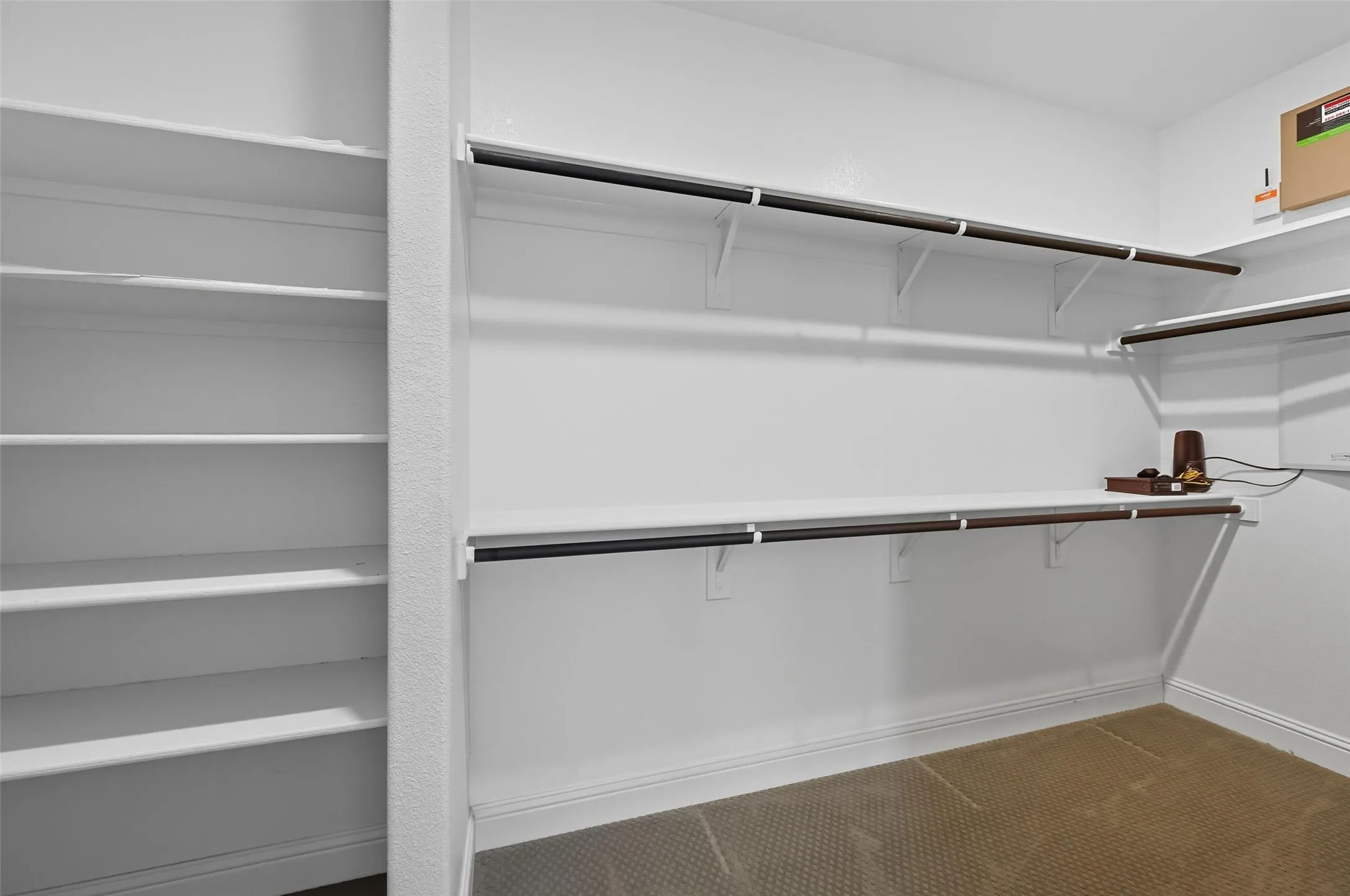 Spacious walk-in closet featuring built-in shelving, multiple hanging rods, and an integrated shelf system