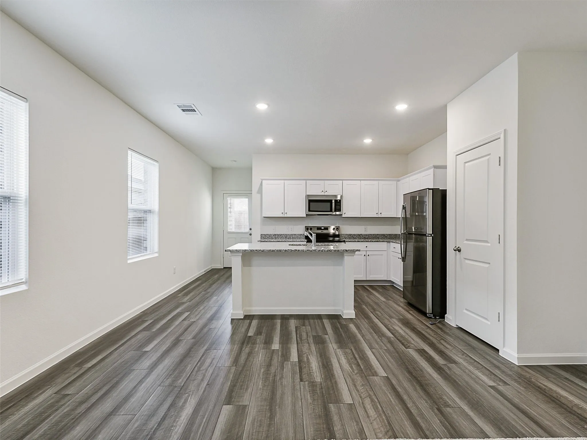 Open-concept living area with wood-finish flooring