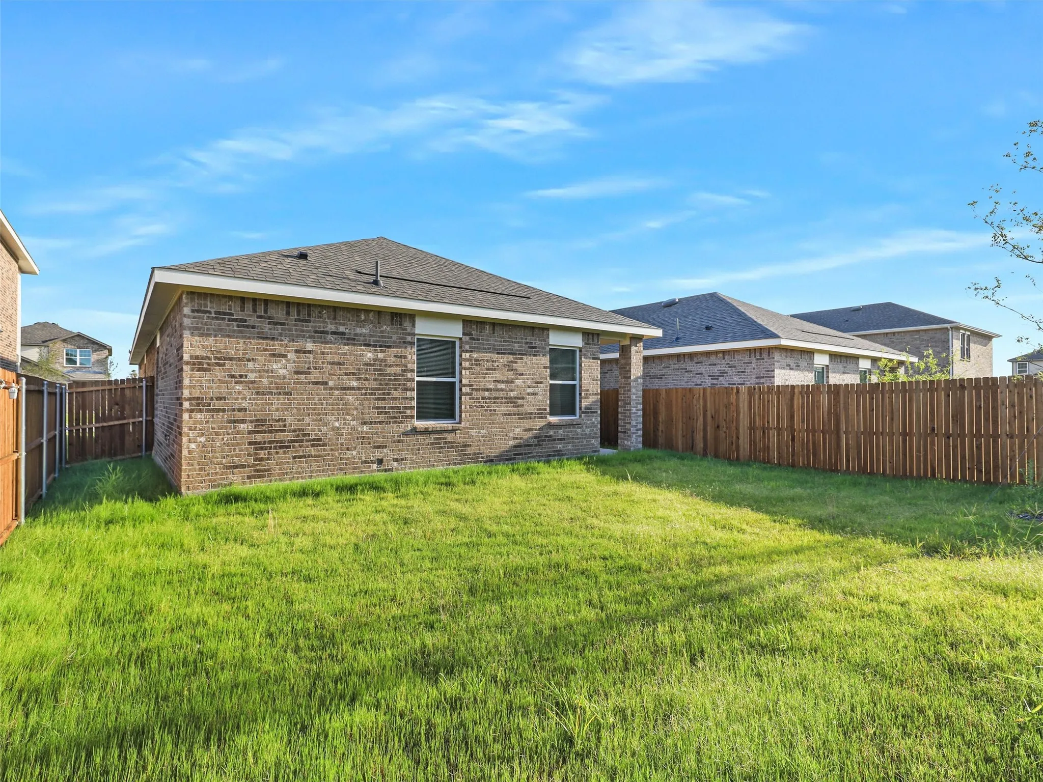 Expansive grassy yard with full privacy fencing