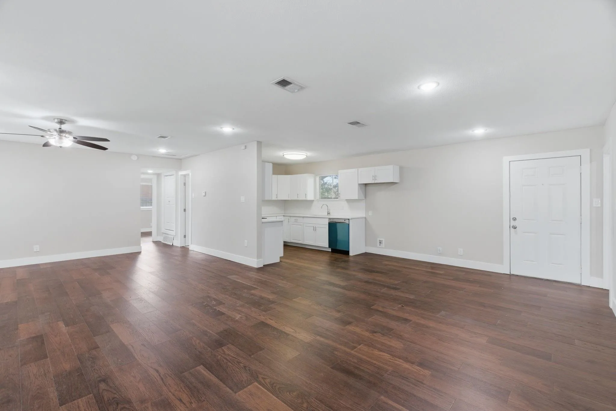 Open-concept living area featuring wood-finish flooring, recessed lighting, and a ceiling fan