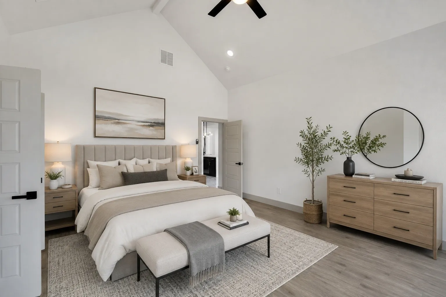 Spacious room featuring a vaulted ceiling and wood-finish flooring