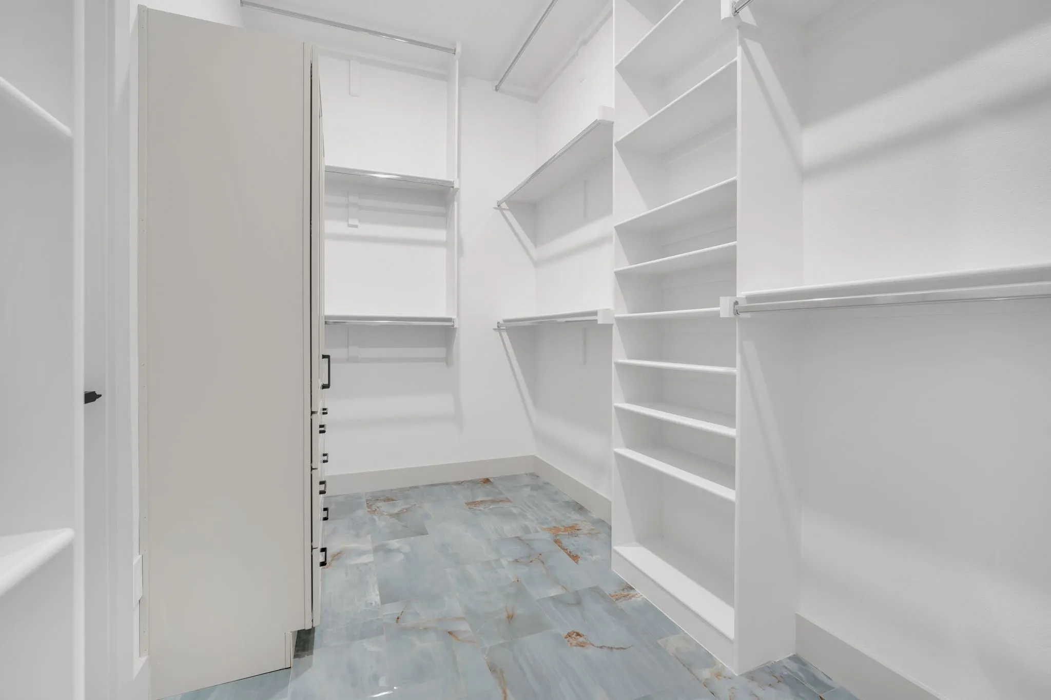 Spacious walk-in closet featuring floor-to-ceiling shelving and built-in storage solutions