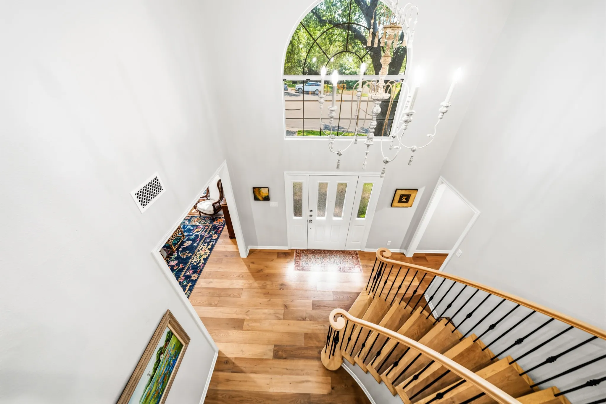 Majestic cathedral ceiling with Roman-arched window above the foyer, and rod-iron & white-oak staircase