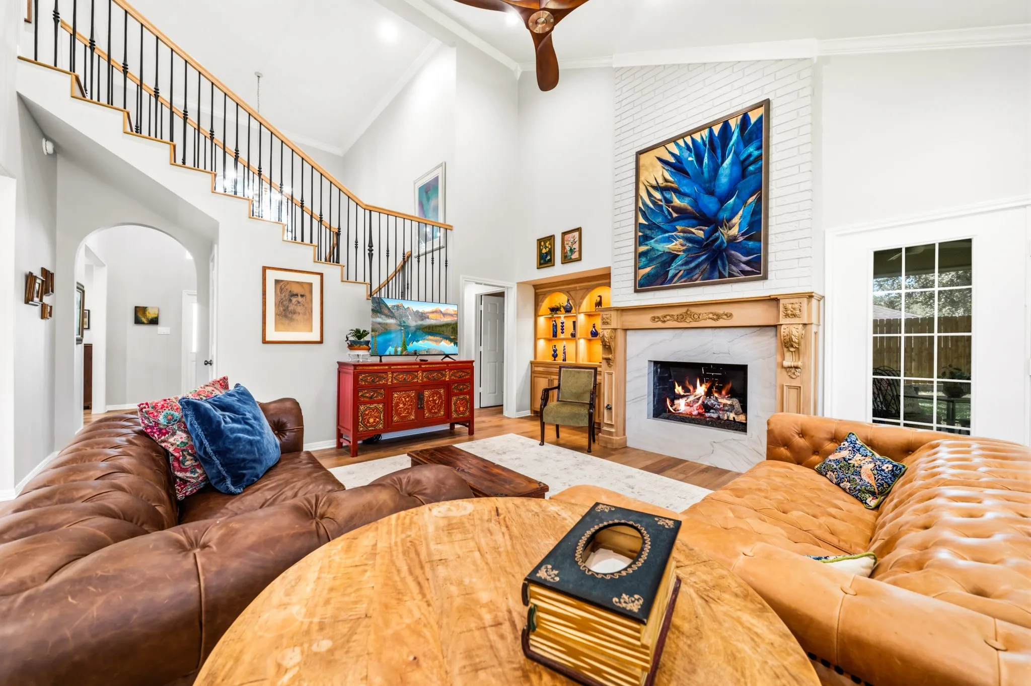Liv Room features natural elements such as white oak bookcases, custom-built mantle, & fireplace surround crafted from quartz.