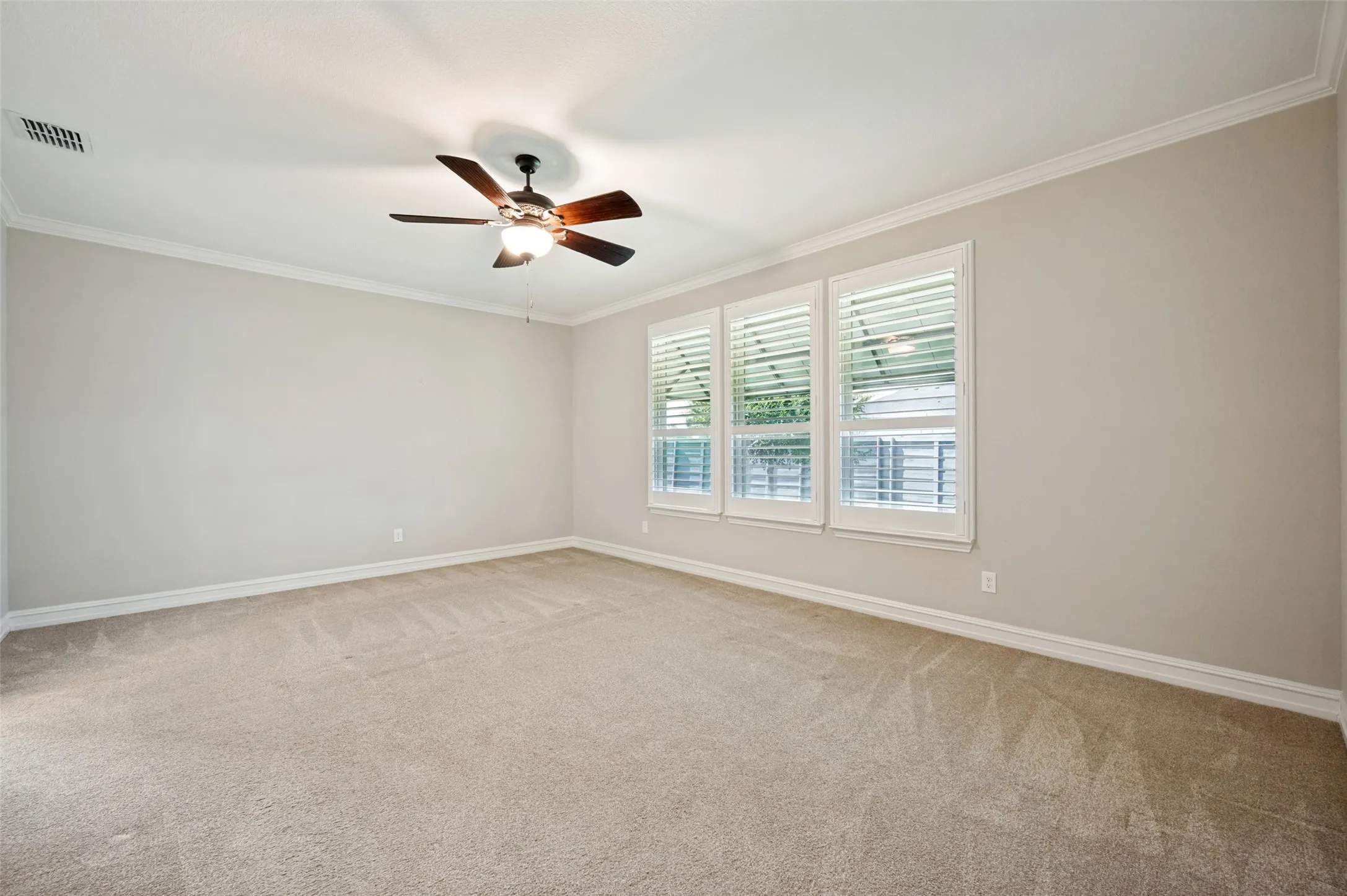 Spacious room featuring neutral carpeting and light-toned walls