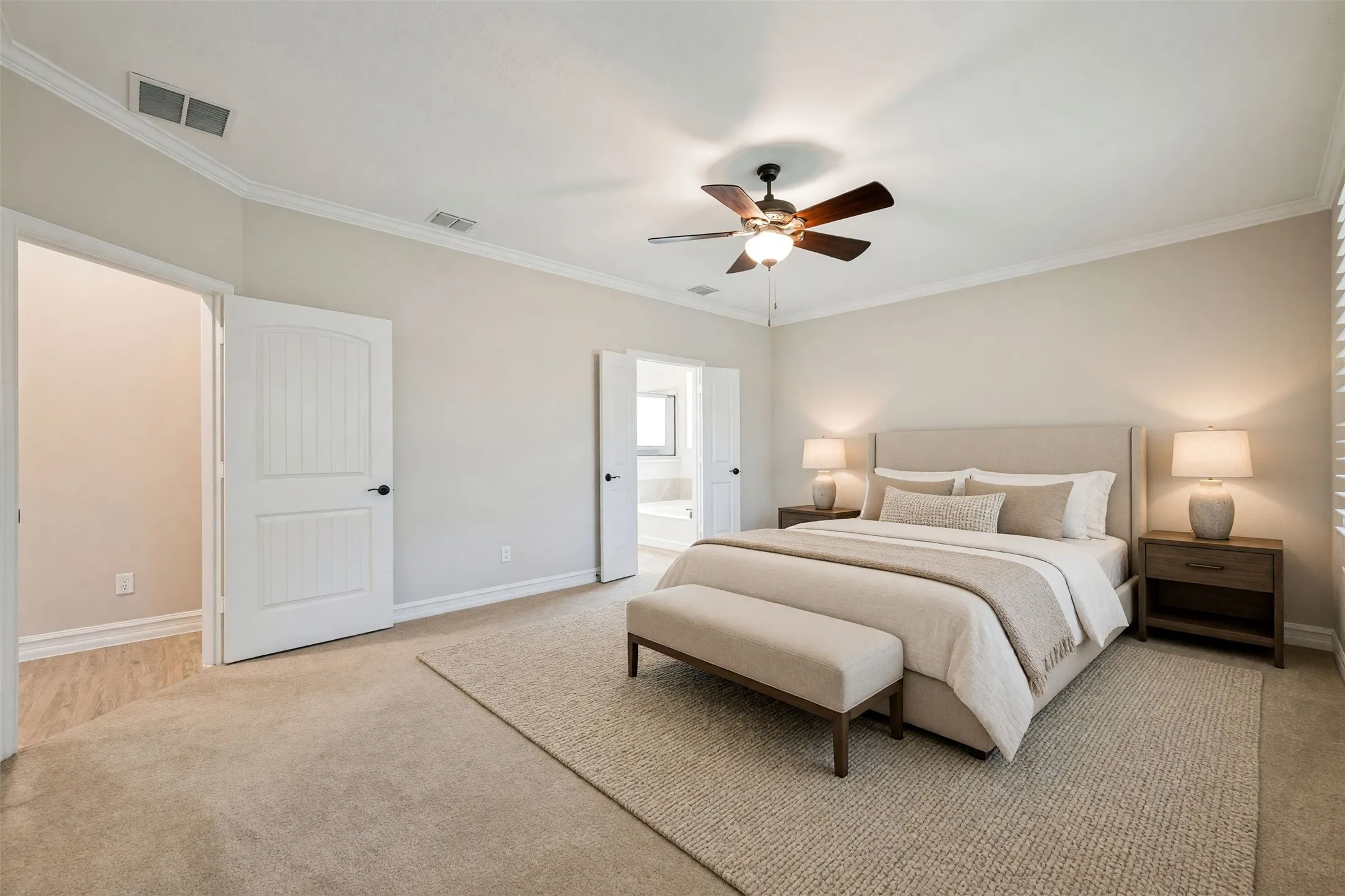 Recessed ceiling with crown molding, ceiling fan with integrated lighting, two paneled interior doors, and carpet flooring/Virtually staged