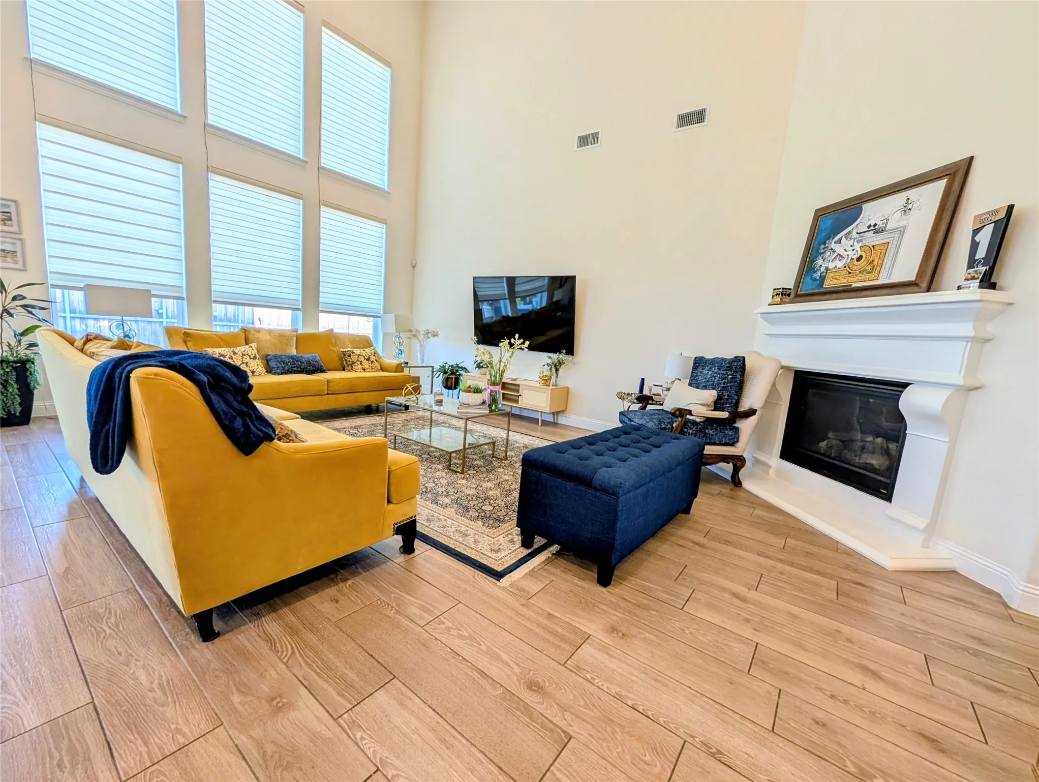 Living space featuring wood-finish flooring and a corner fireplace with a white mantel