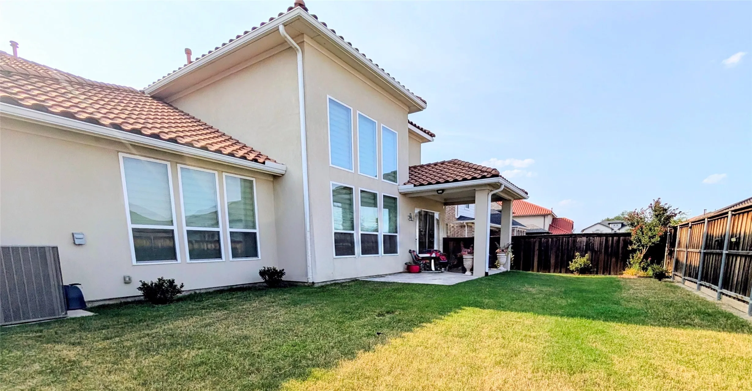 Contemporary home with clean-lined architecture featuring a two-story design with peaked roofline and clay tile roofing