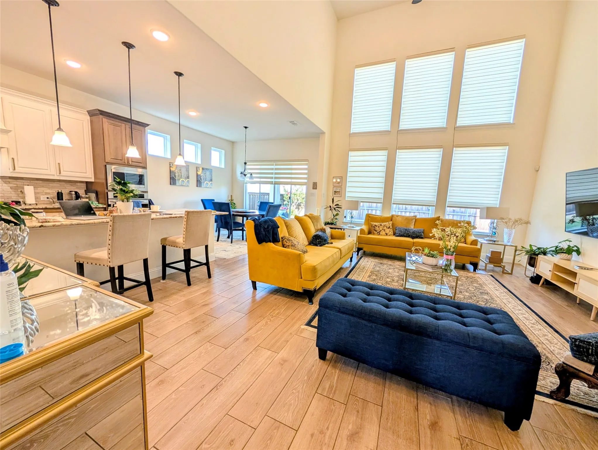 Expansive open-concept living area featuring a vaulted ceiling and a wall of six large windows