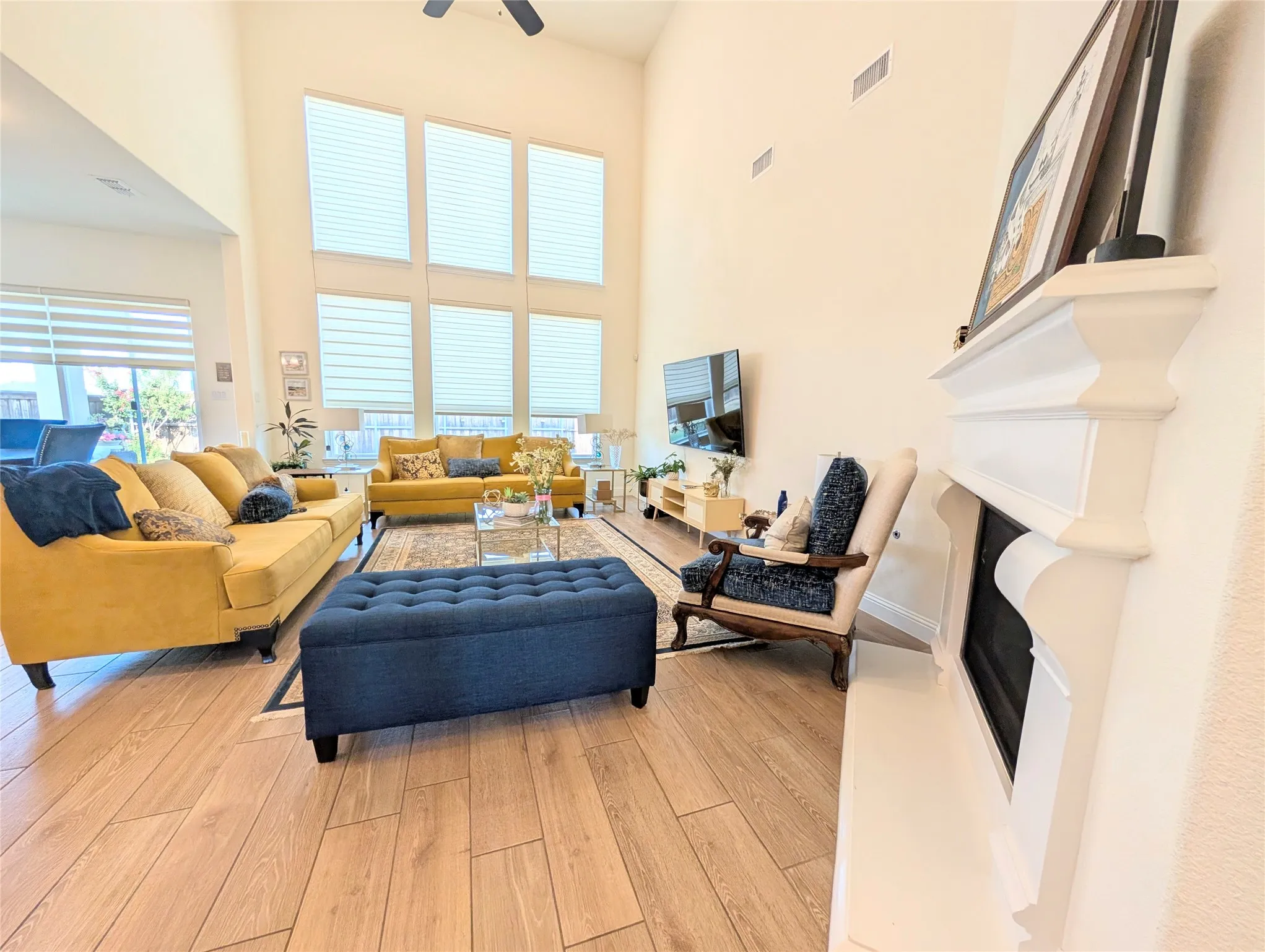 Two-story living room featuring a vaulted ceiling and extensive multi-pane windows
