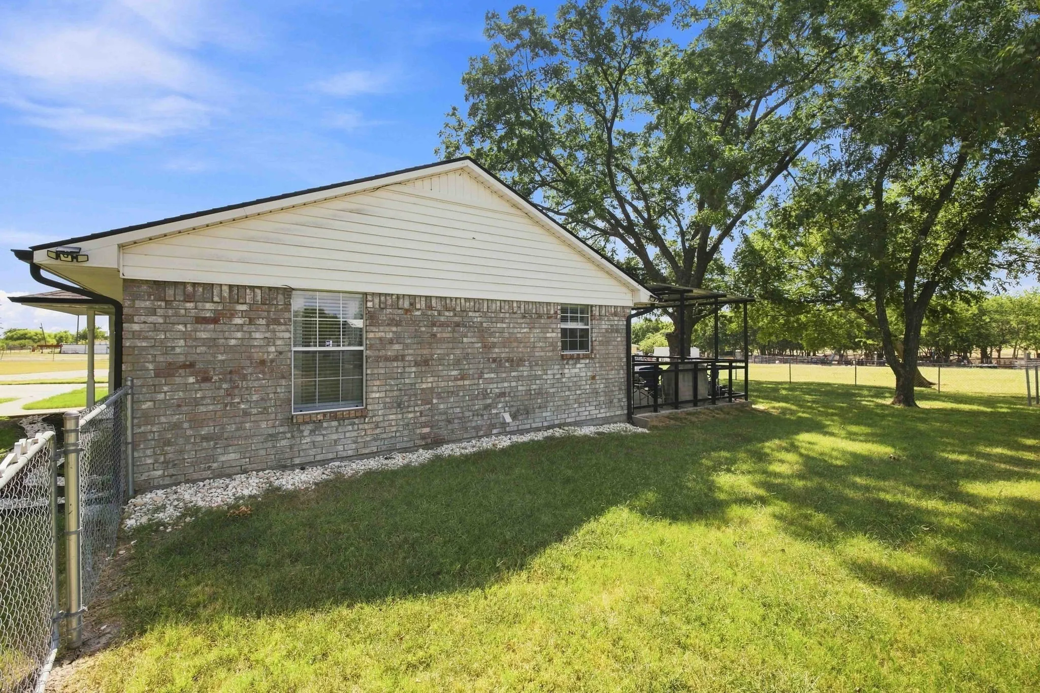 Brick and siding exterior with a dark shingle roof