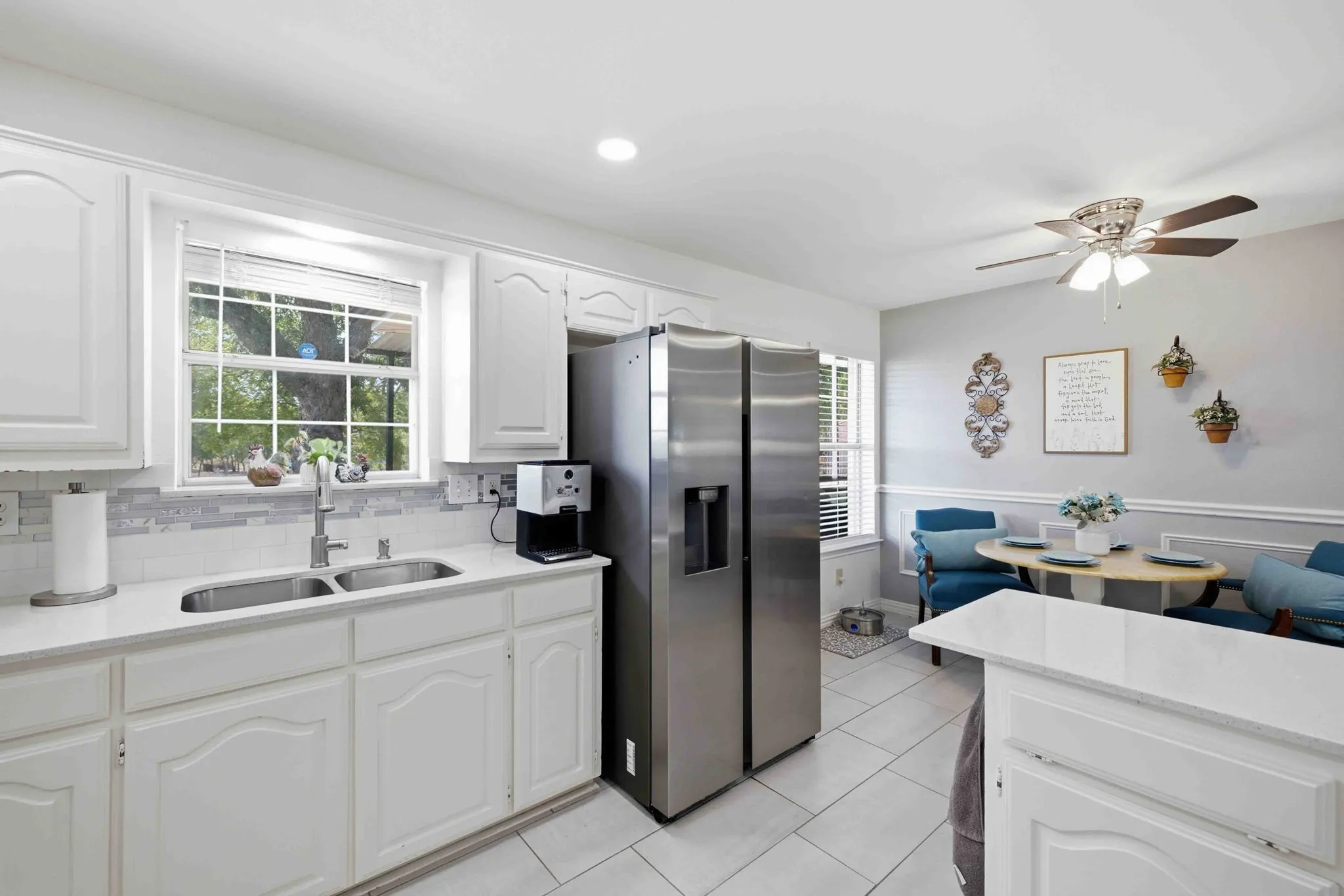 Kitchen featuring white cabinetry, stainless steel appliances, a double basin sink, and tile flooring
