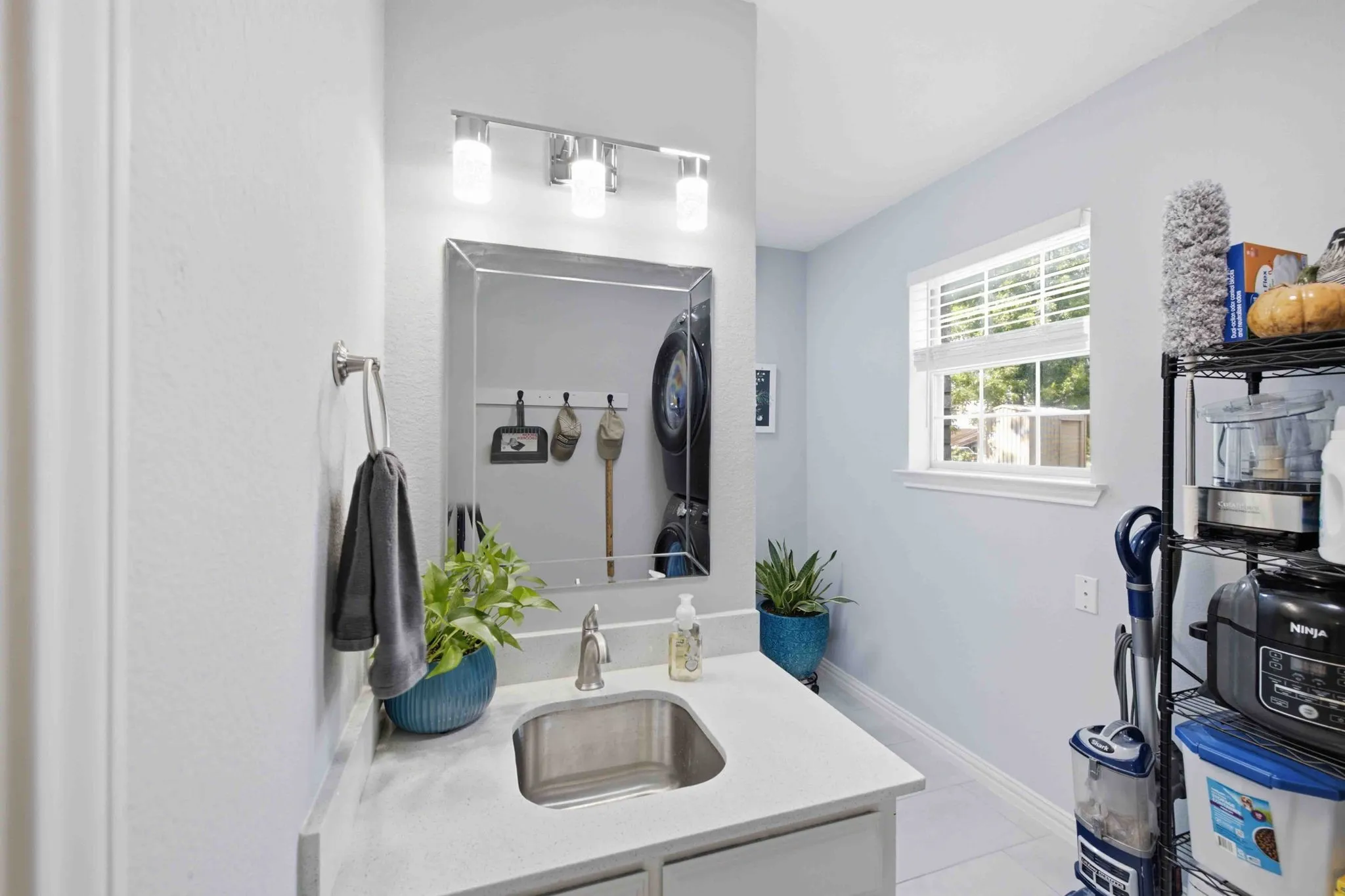 Single-basin stainless steel sink with a polished chrome faucet, set into a light-toned countertop