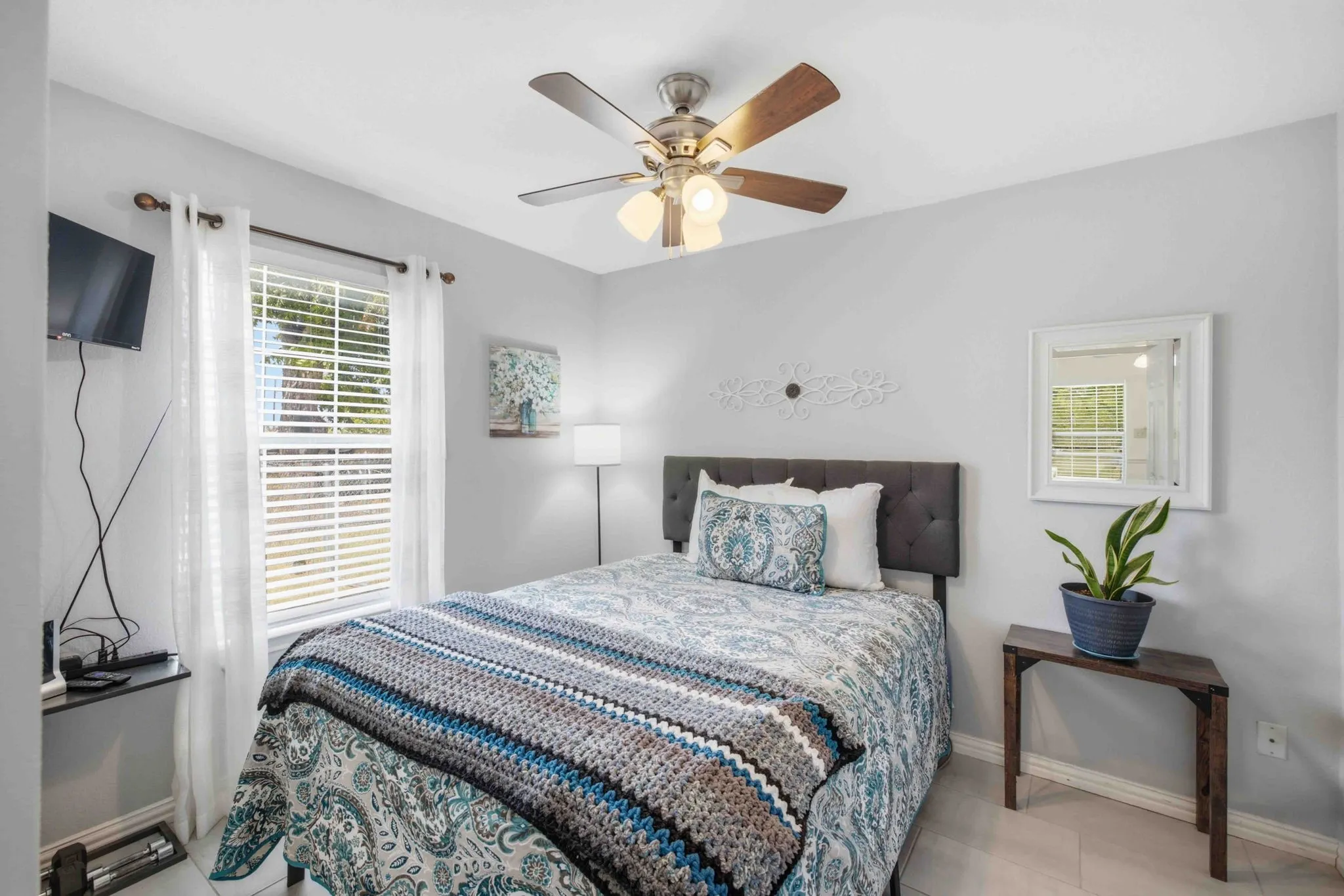 Recessed lighting, ceiling fan with light fixture, window with blinds, wood-finish flooring, and a gray upholstered headboard