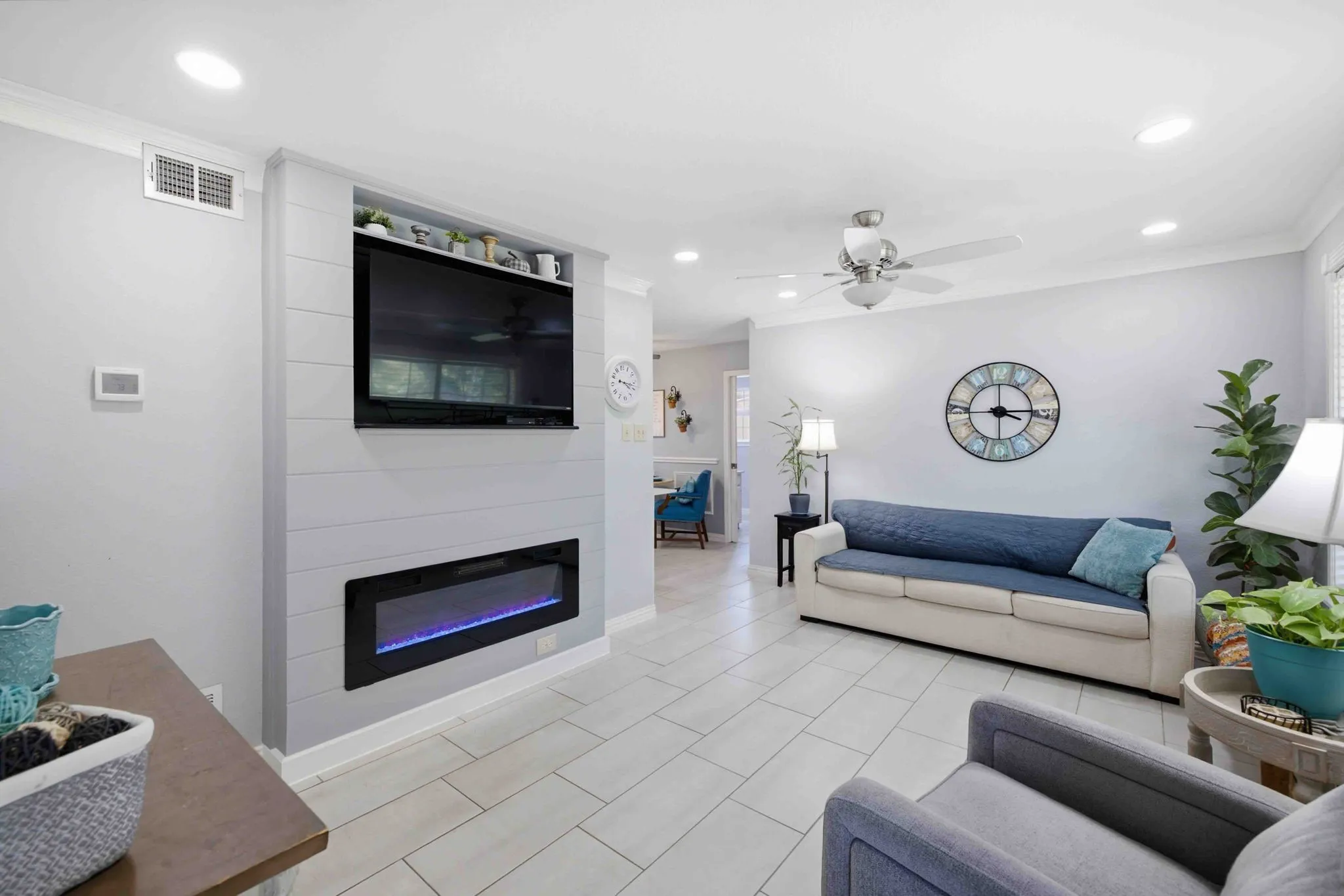 Recessed lighting throughout, ceiling fan, crown molding, electric fireplace, and tile flooring