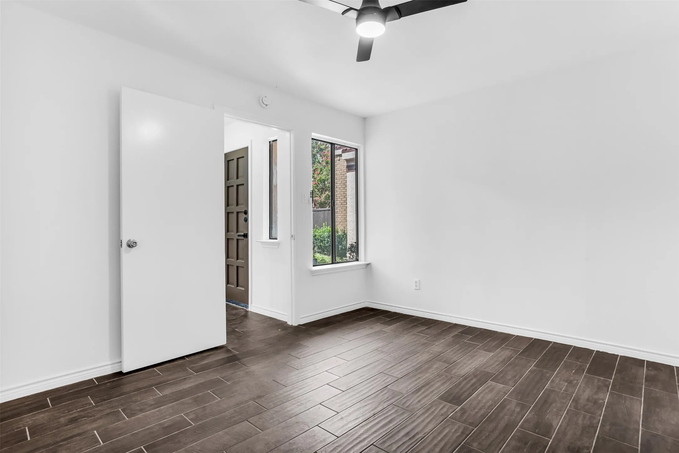 Wood-finish flooring, white walls, and a contemporary ceiling fan