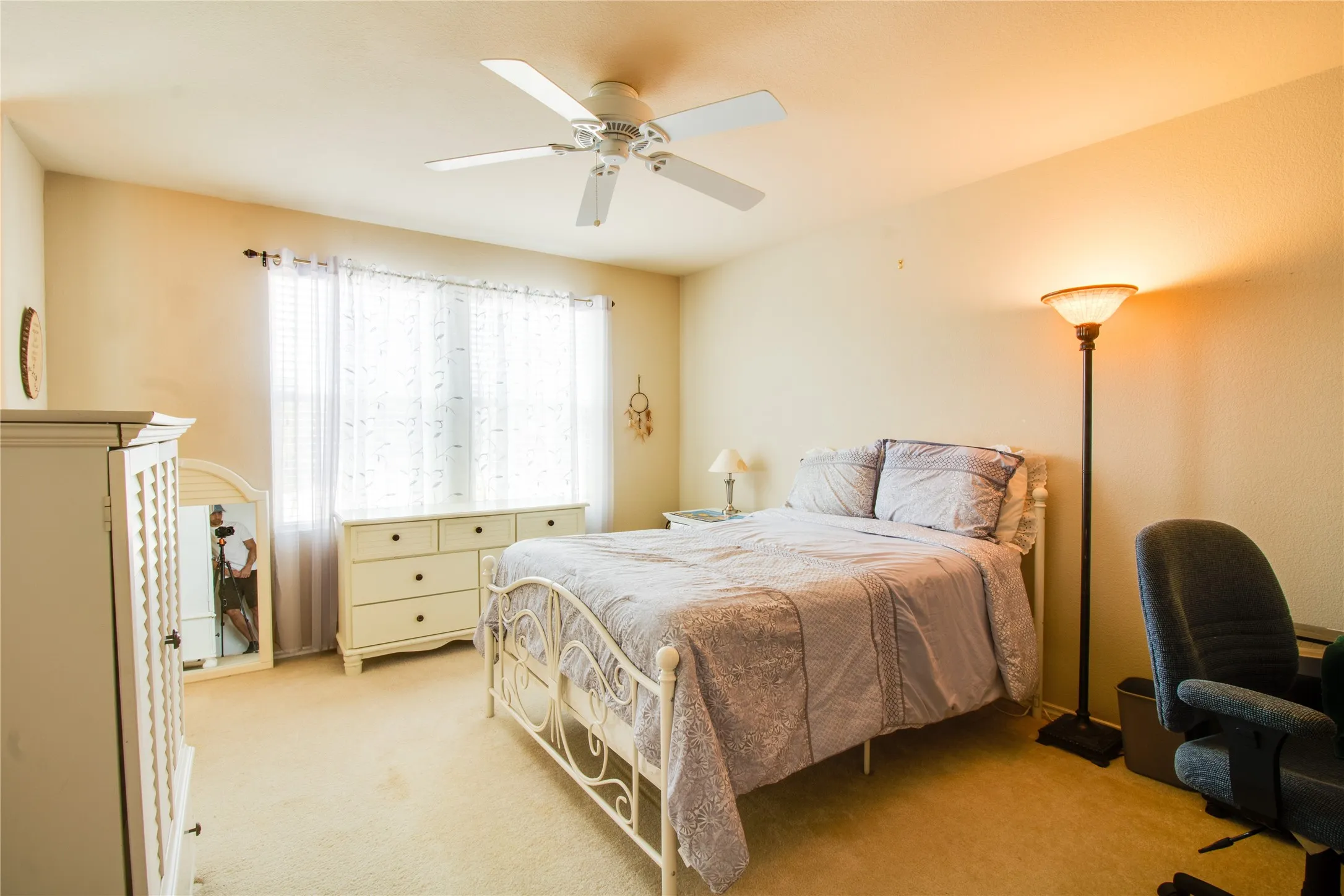 Carpeted room featuring a ceiling fan with integrated lighting, a window with blinds, and neutral-toned walls