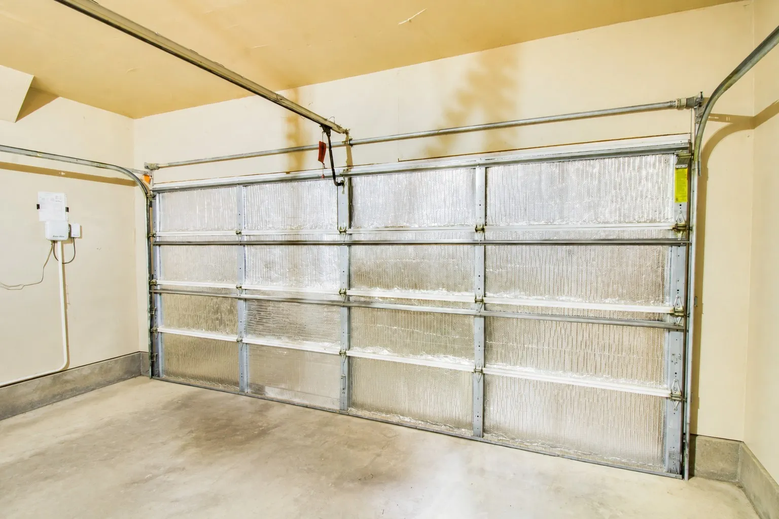 Insulated garage door with overhead track system