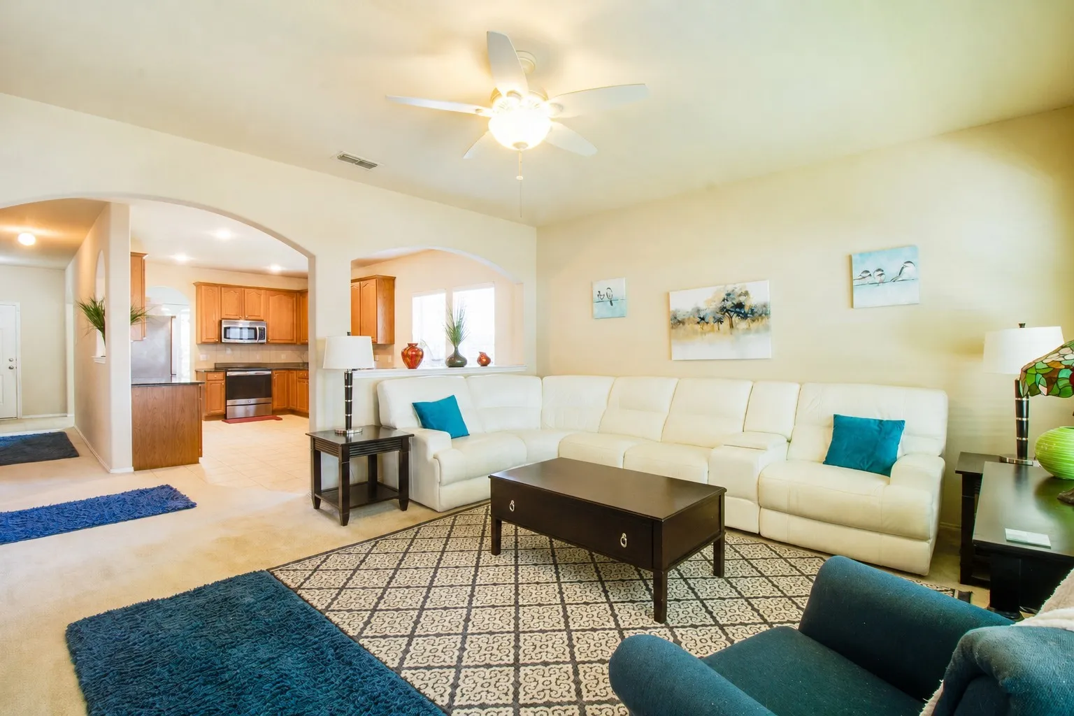 Archway entryways, recessed lighting, ceiling fan, wood-finish cabinetry, and stainless steel appliances