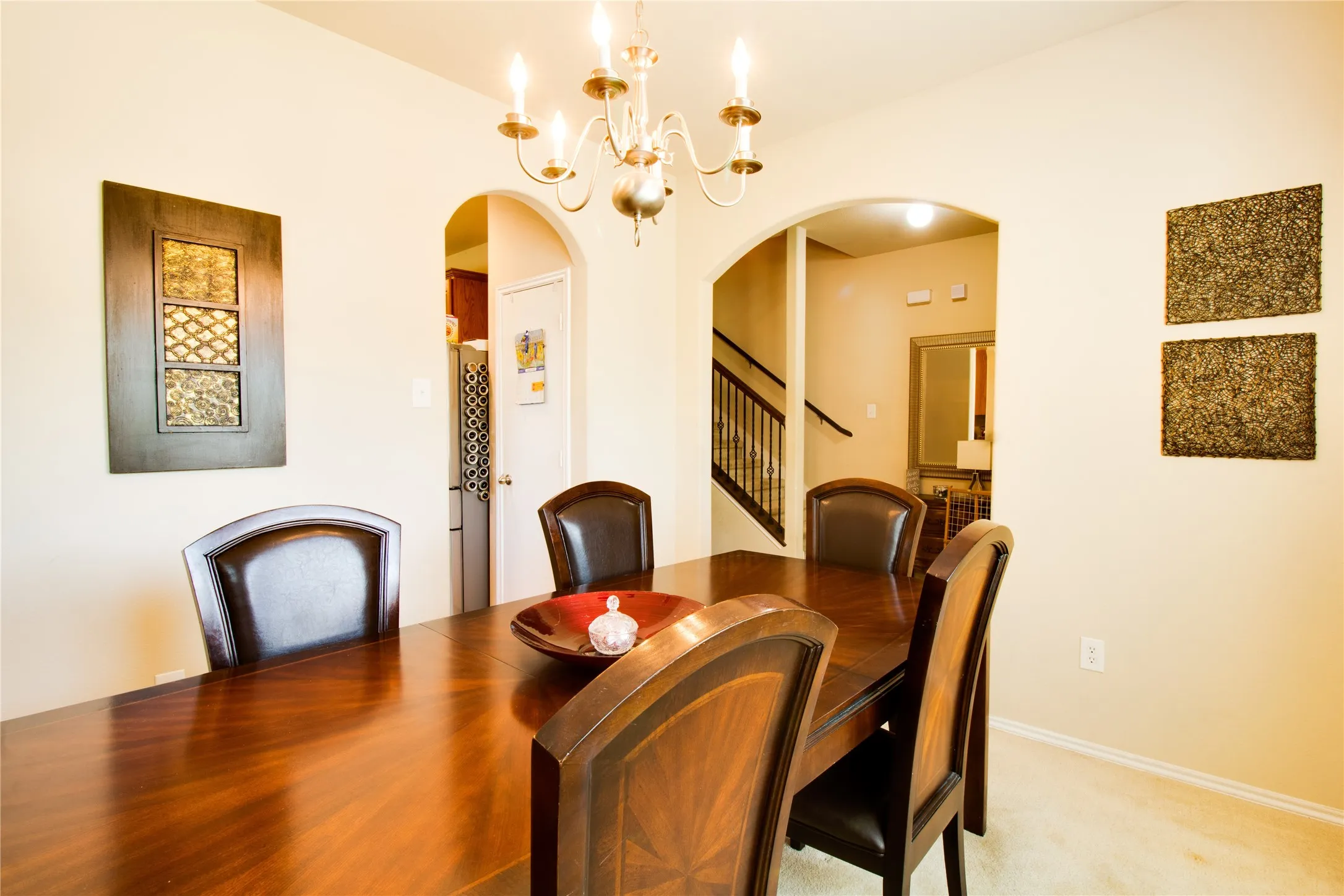 Dining area featuring an arched doorway, chandelier lighting, and neutral wall tones