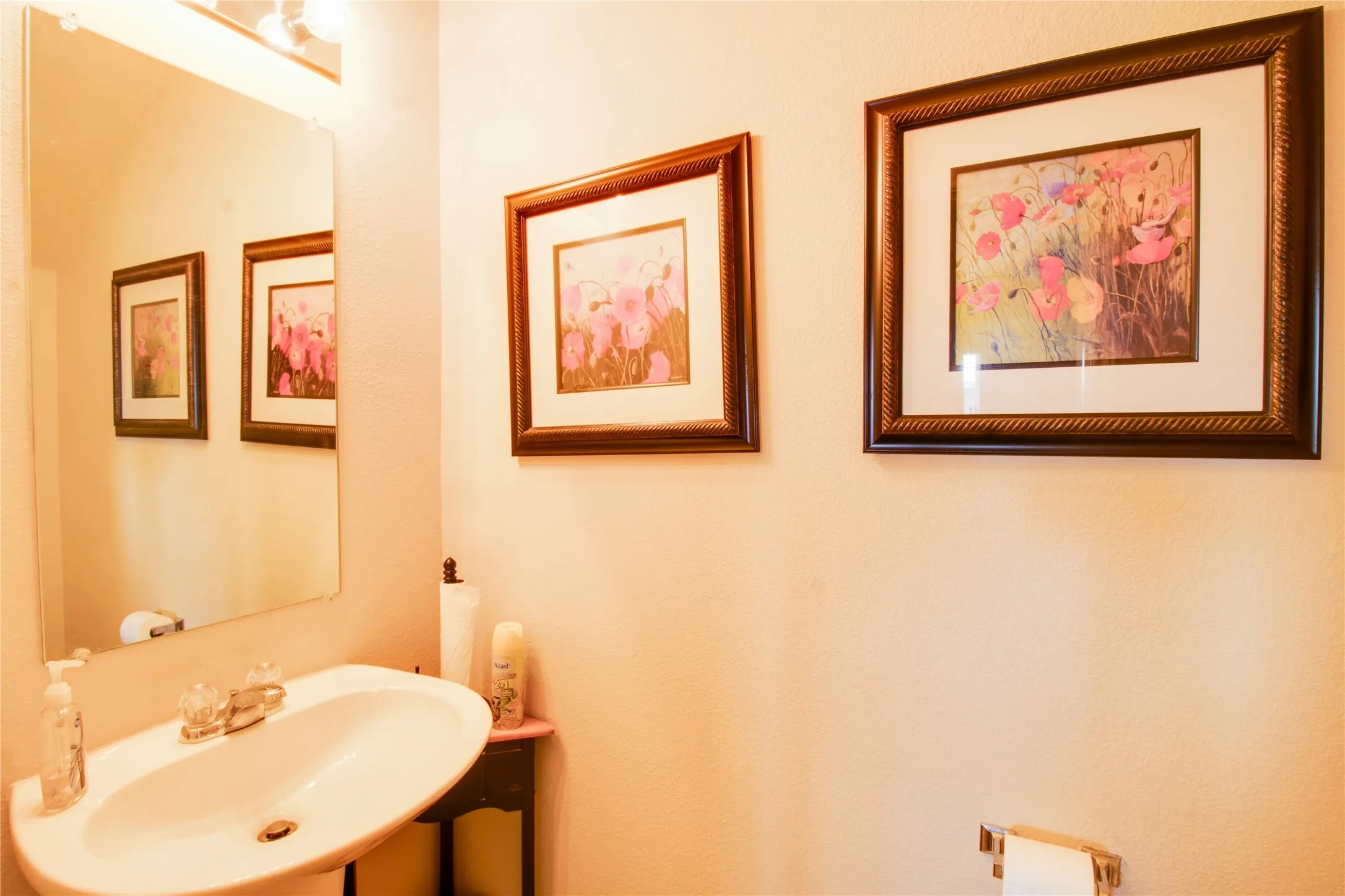 Pedestal sink with dual-handle faucet and wall-mounted mirror