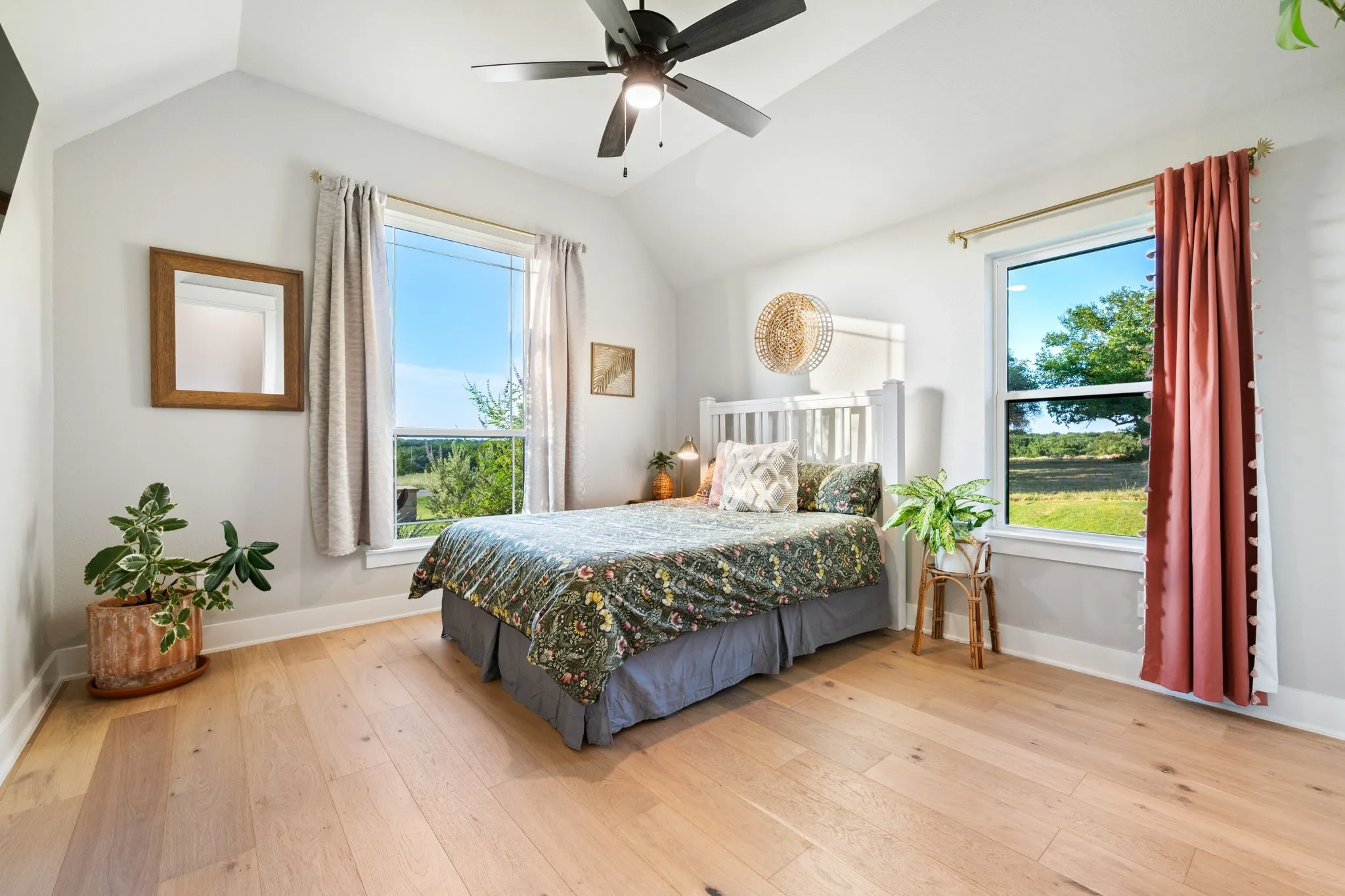 Bedroom featuring vaulted ceiling, walk in closet and a ceiling fan