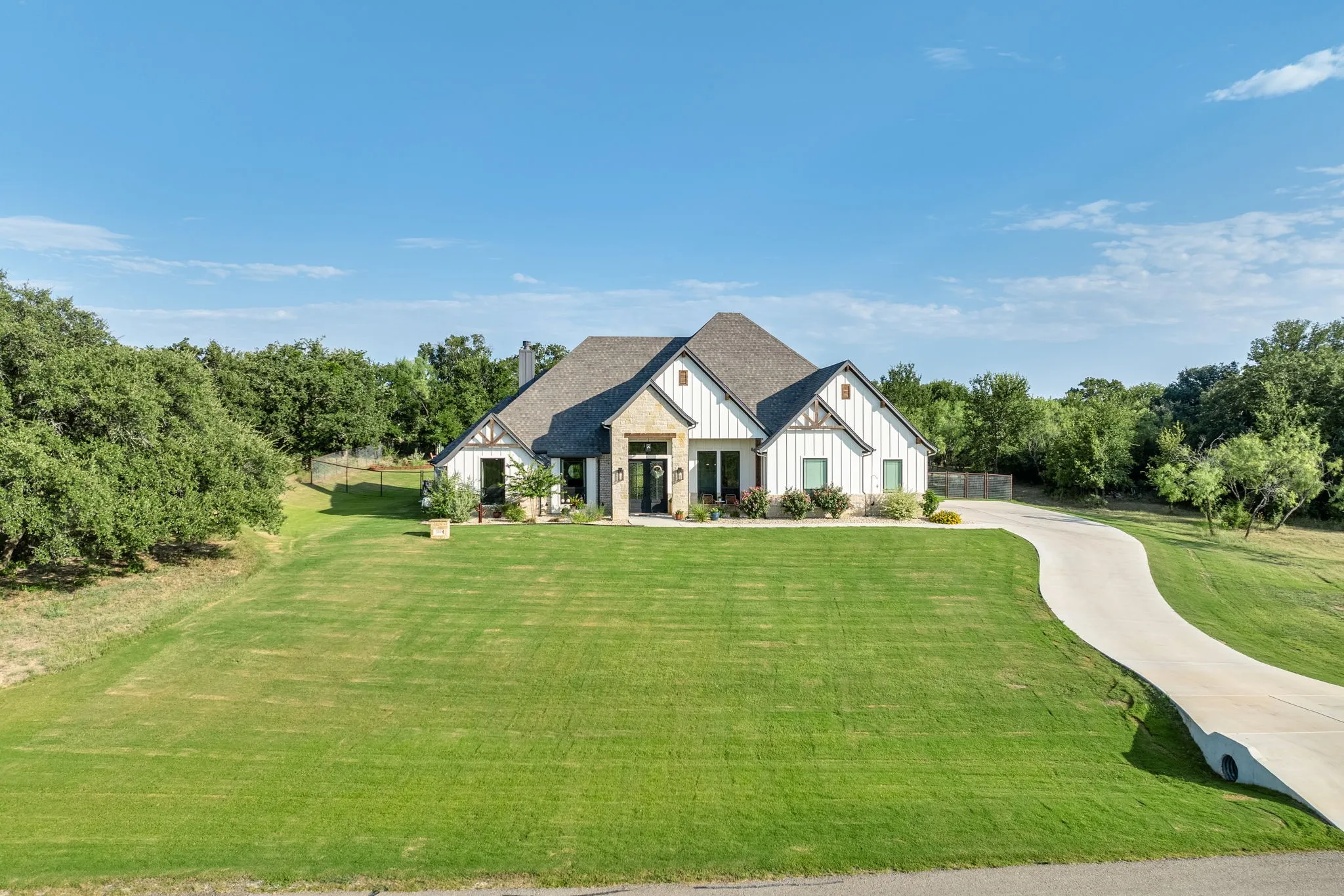 Elegant one-story residence featuring a brick and stone exterior with a steeply pitched roof and multiple gables