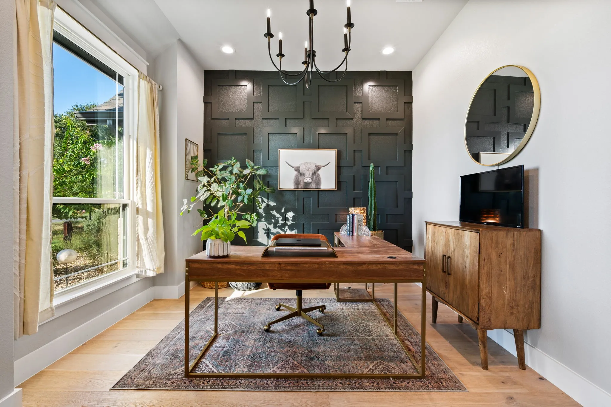 Dedicated room featuring an accent wall with geometric paneling, a contemporary chandelier, and a large window currently used as a home office