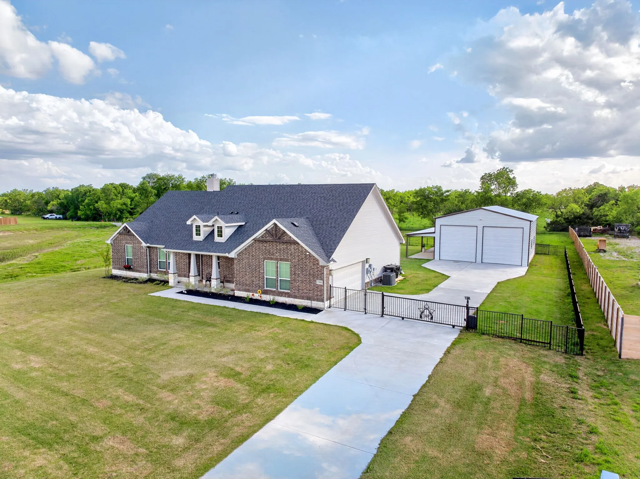 Brick facade residence with a dark shingle roof and white trim