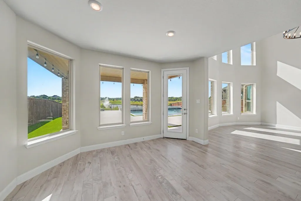 Wood-finish flooring, recessed lighting, and multiple windows with white trim