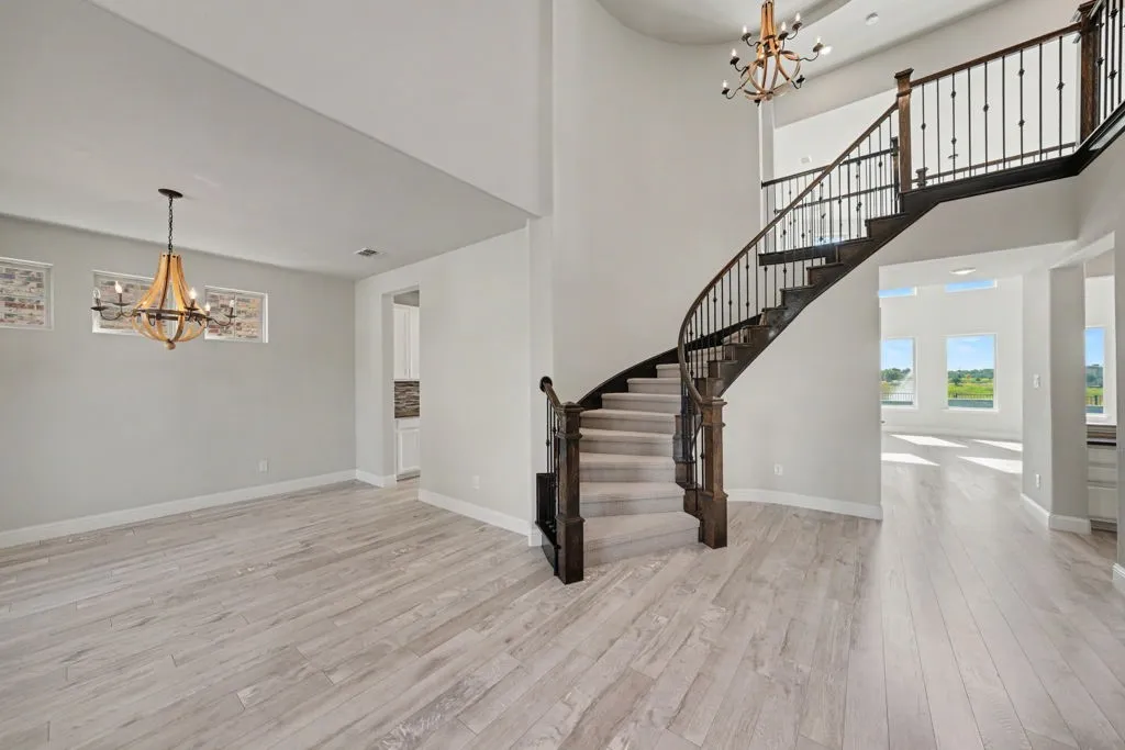 Grand curved staircase with wrought iron balusters