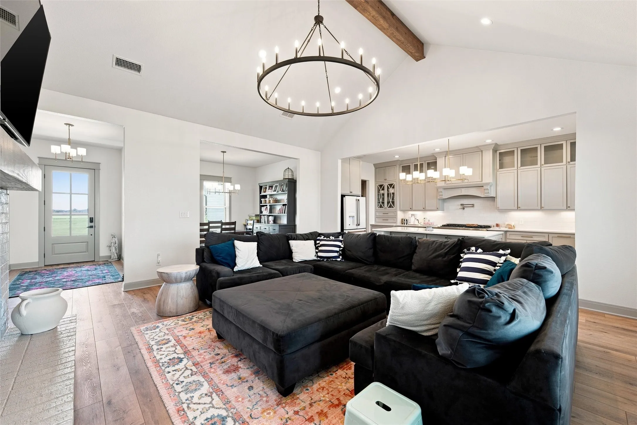 Vaulted ceiling with an exposed beam and a large chandelier