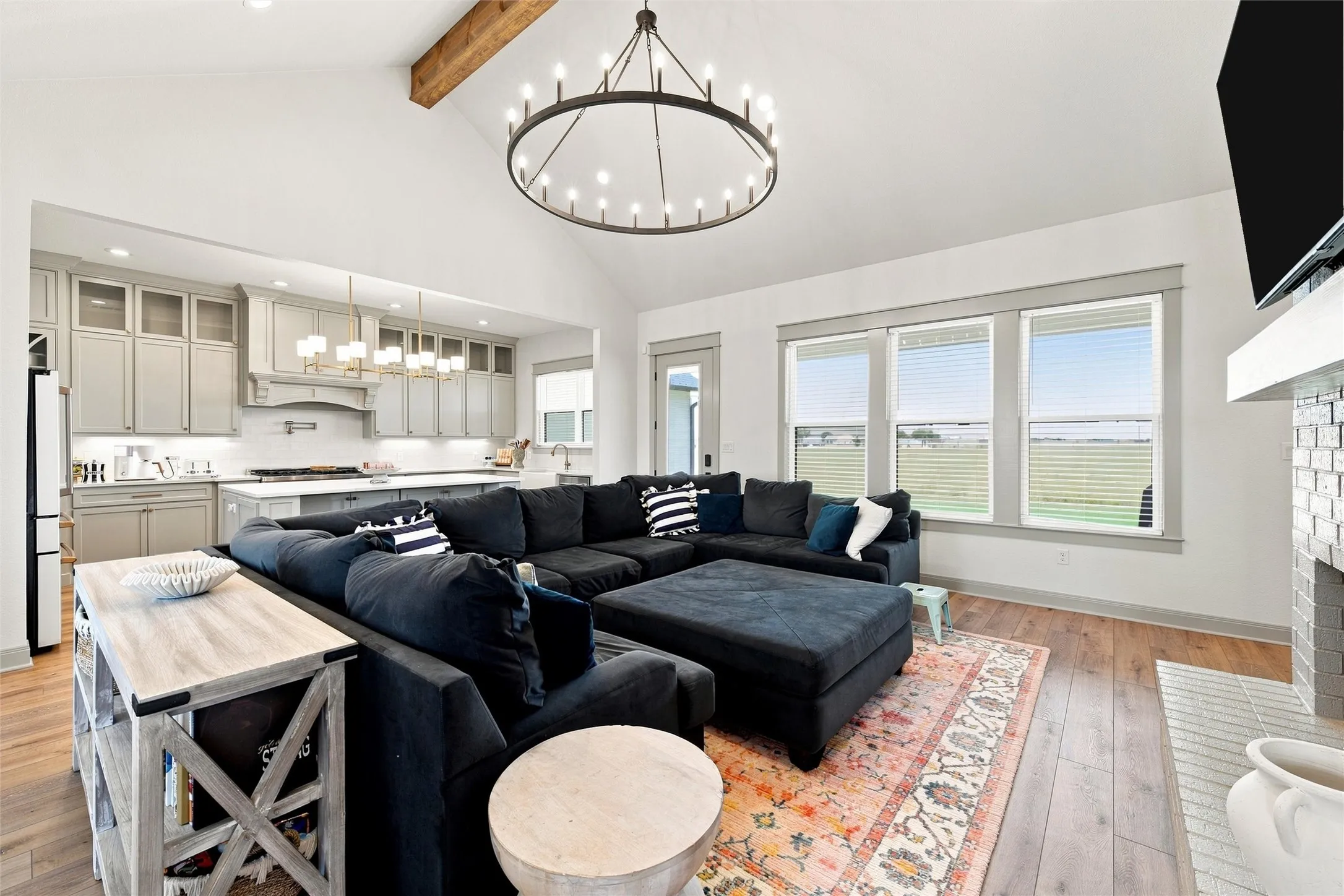 Open-concept living space with a vaulted ceiling and exposed wood beam