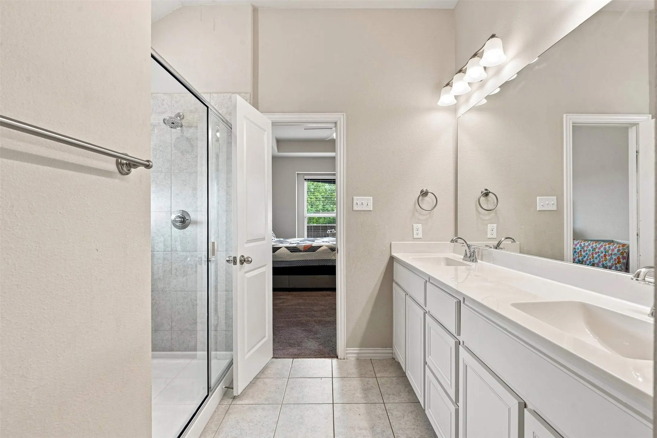Double vanity with light-toned countertop, dual sinks, and polished chrome fixtures