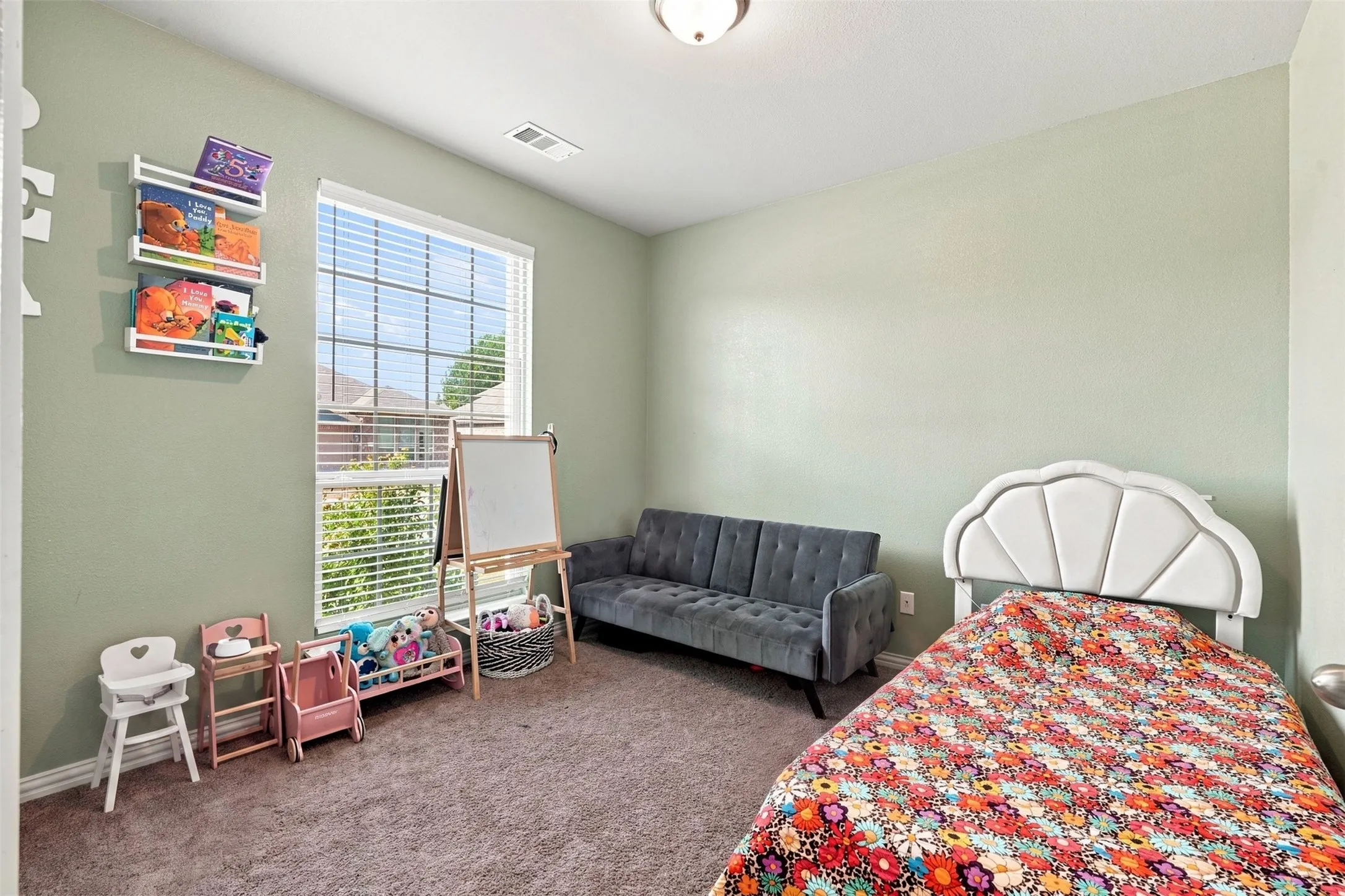 Carpeted room with a large window featuring horizontal blinds