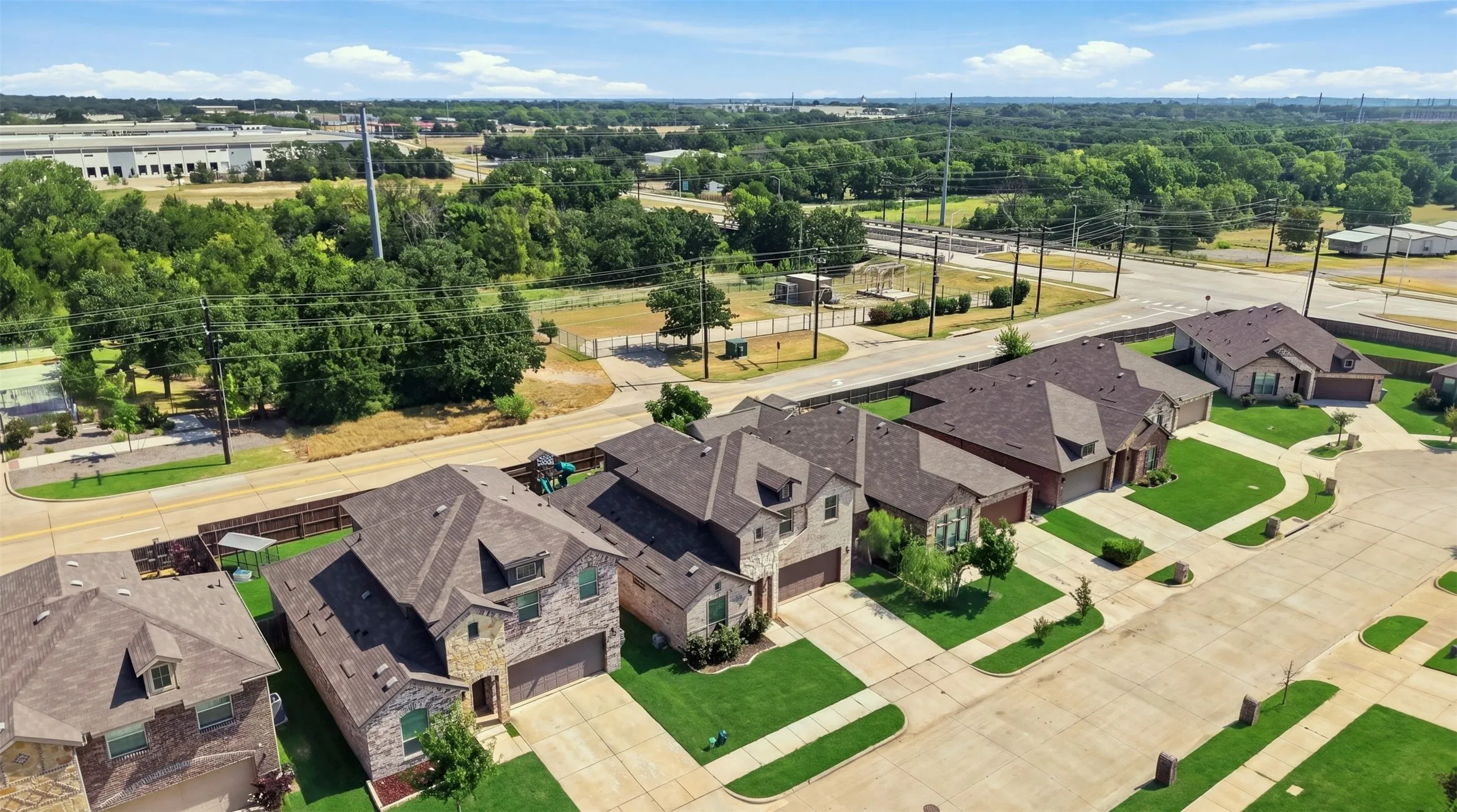 Aerial perspective showcasing a residential street lined with single-family homes, each featuring distinct architectural styles