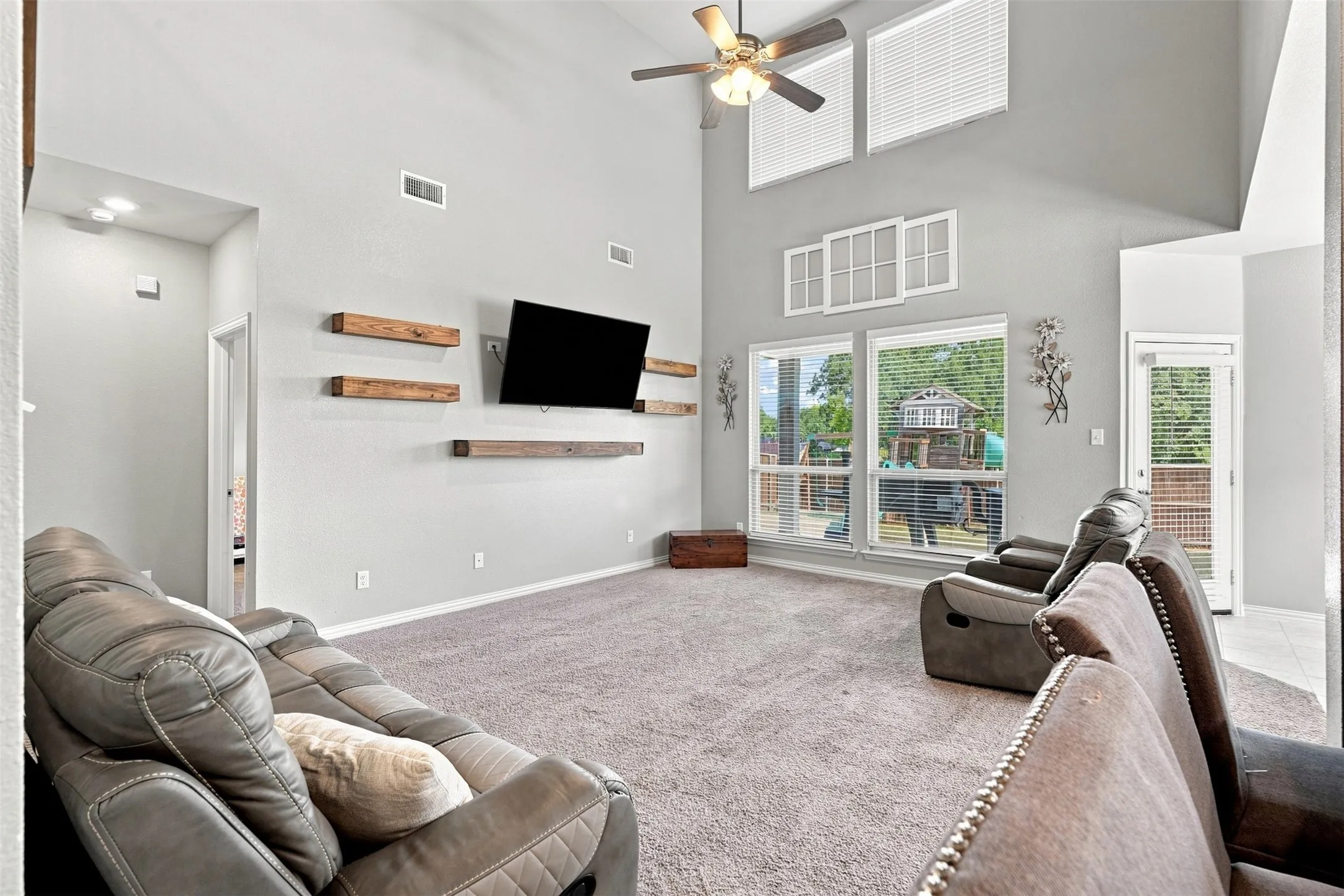 Spacious interior featuring a vaulted ceiling and a ceiling fan