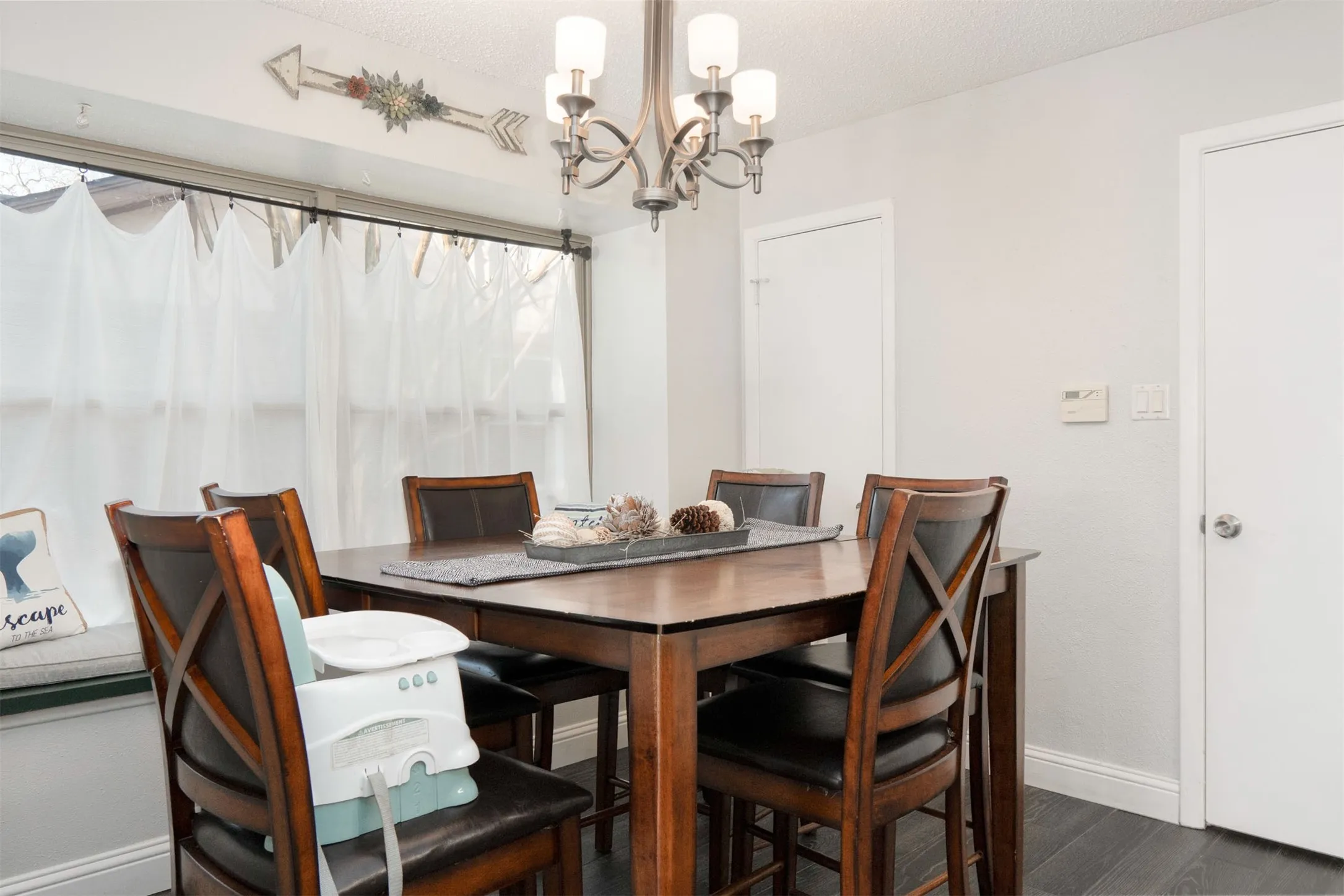 Dining area featuring dark wood-finish flooring and light-toned walls