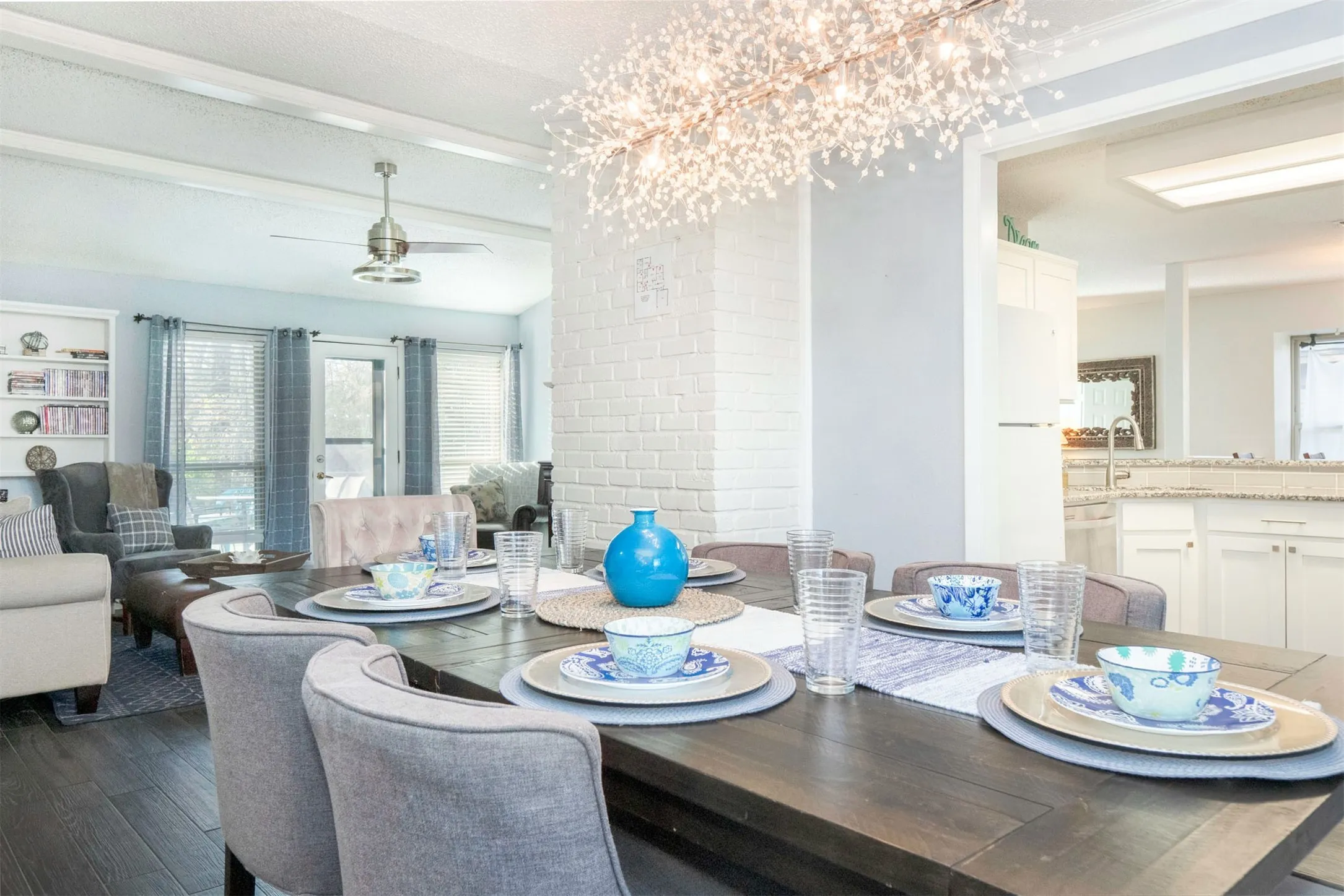 Open concept dining area featuring wood-finish flooring and a contemporary chandelier