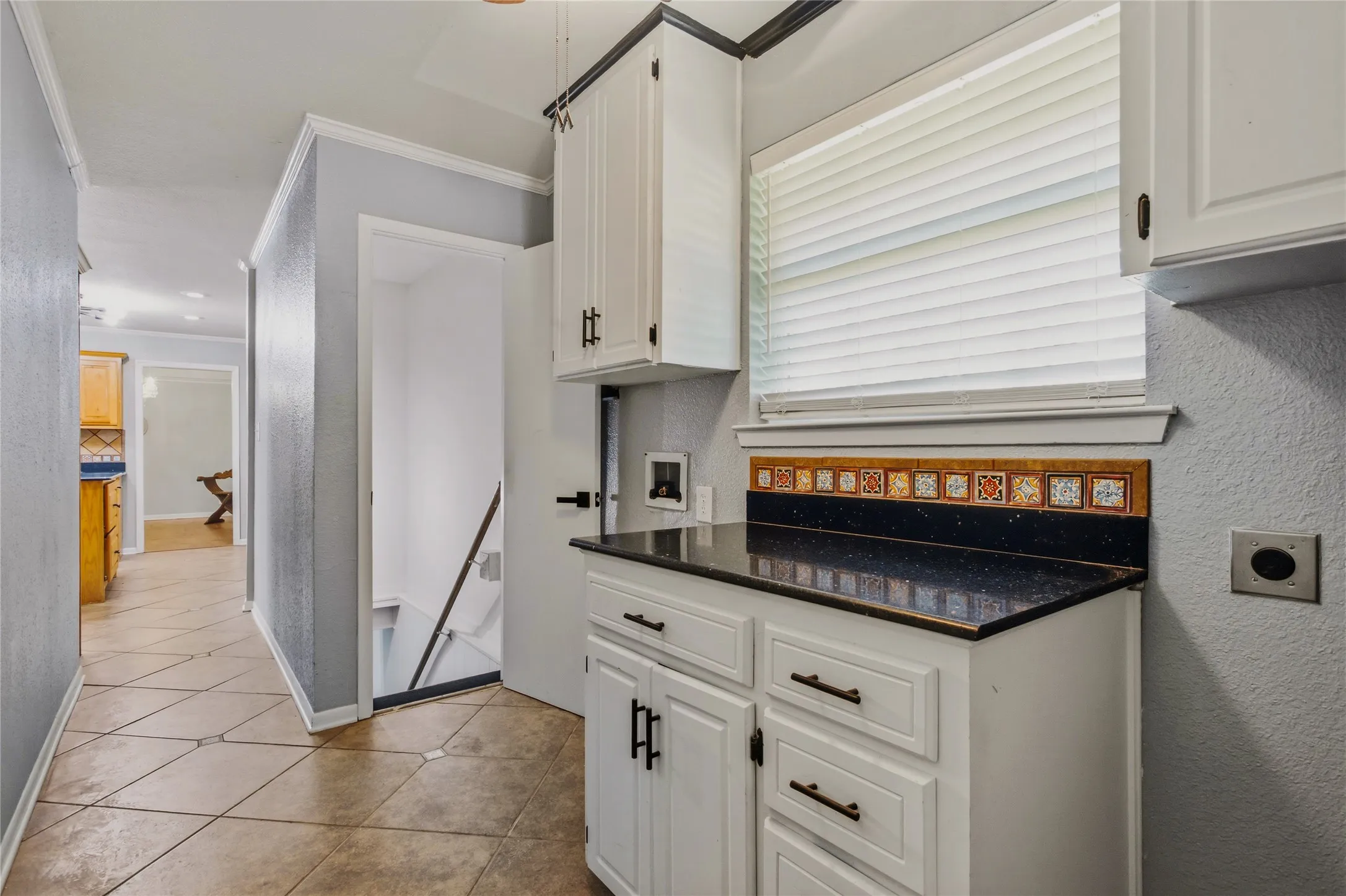 Leaving the basement from the other side of the room, you would go up the stairs to the laundry room.  The laundry room is between the kitchen and the door to the 3-car main floor garage.