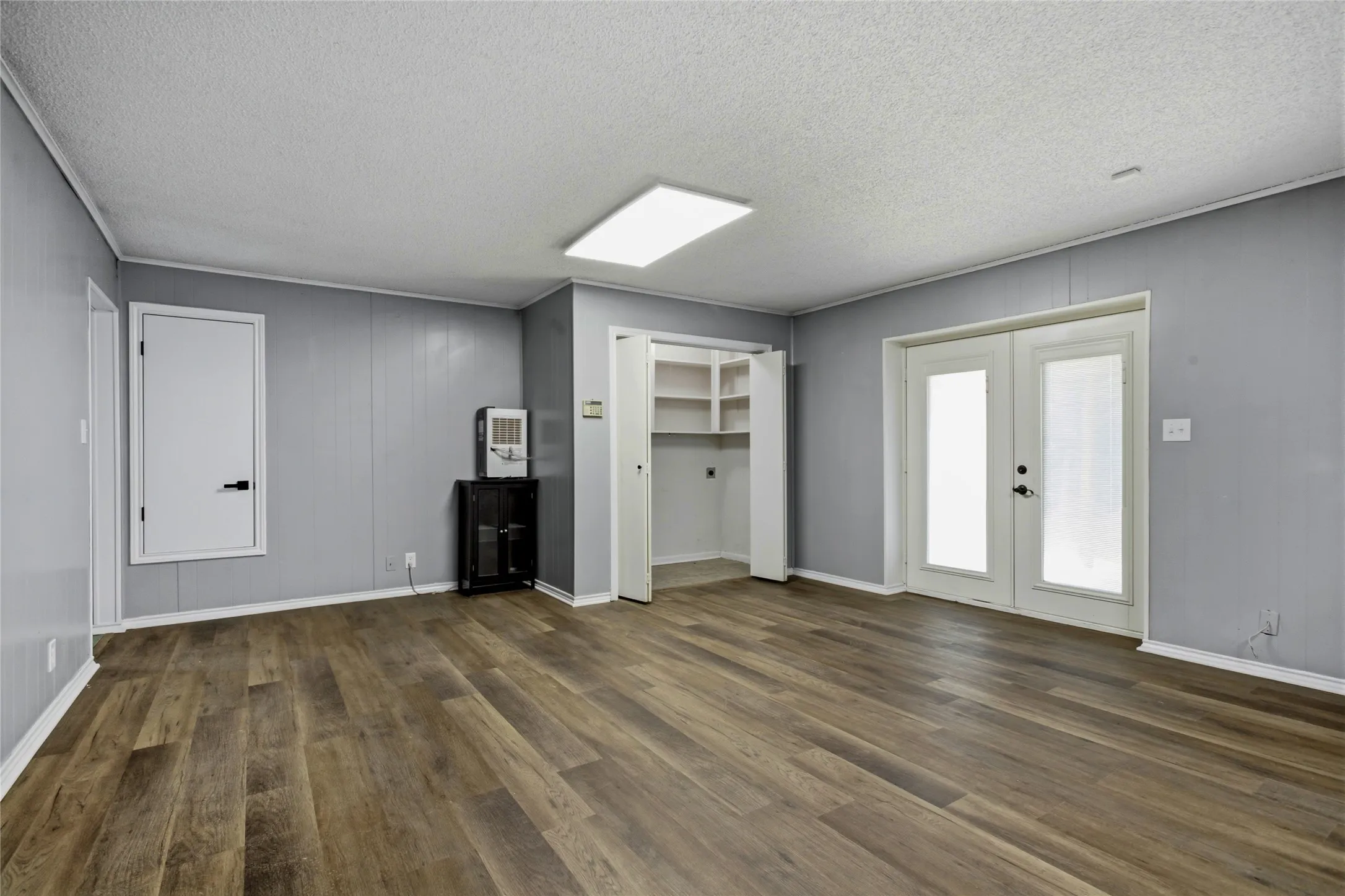 The opposite end of the great room has the laundry room, the HVAC, and the French doors to the back patio that is on the ground level.