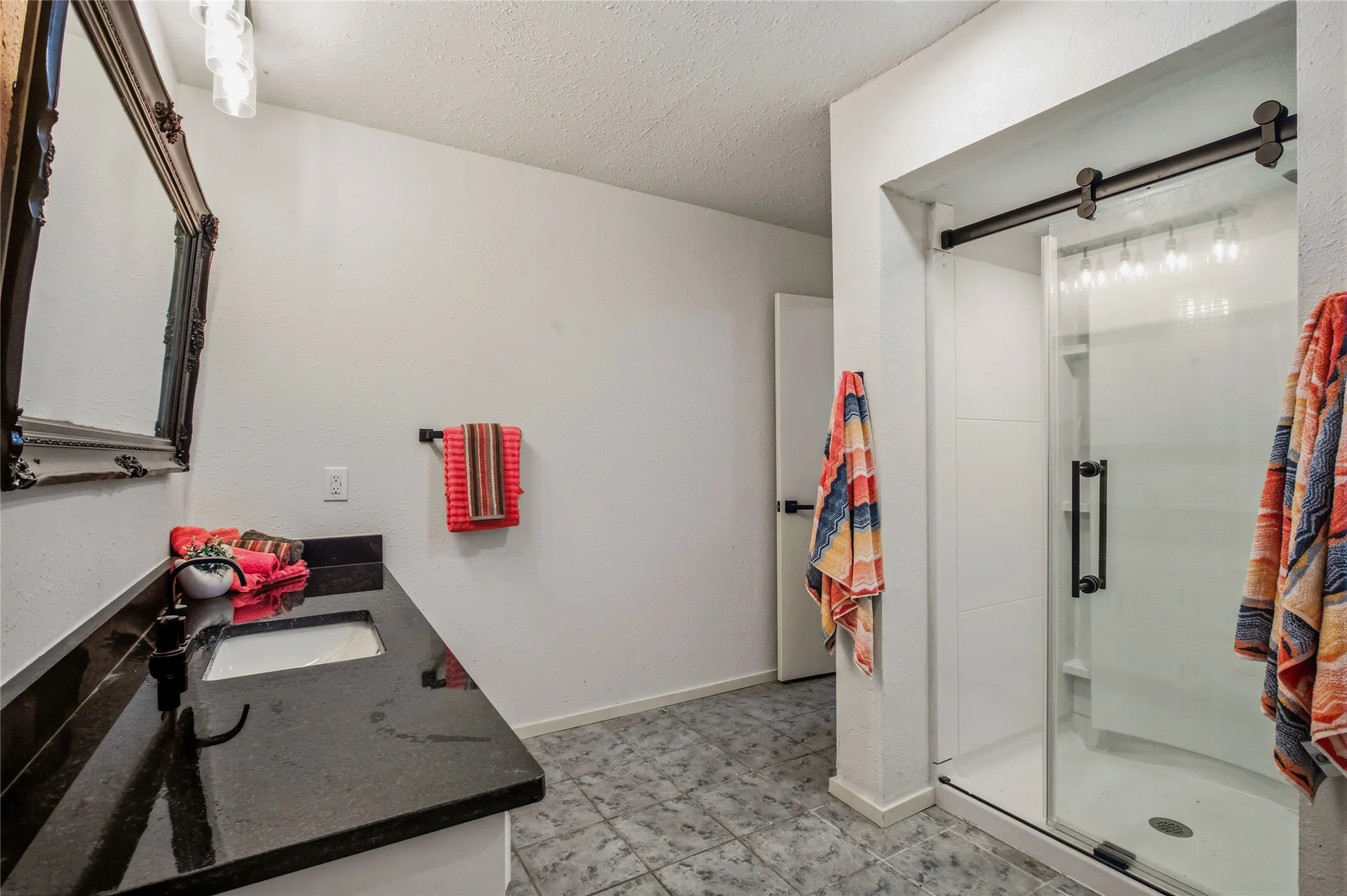 This bathroom has a large shower, long vanity, and room to add more storage.