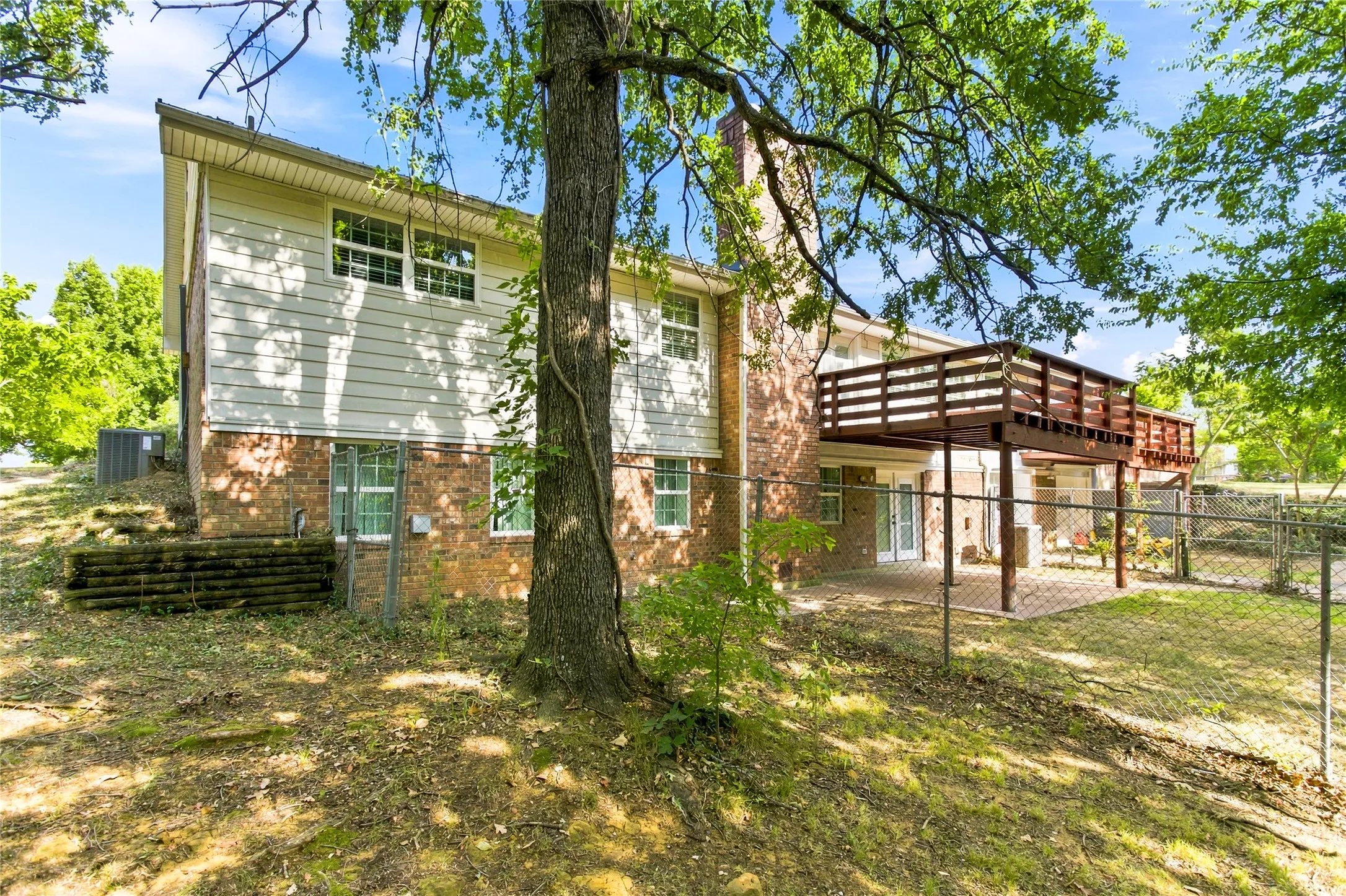 The back of the home shows the retreat-like setting with 2 back decks overlooking beautiful trees including large mimosa trees.  The desk on the left comes off the living room and the deck on the right comes off the primary bedroom.  Below the living room deck, is the lower deck/or porch area for private barbeques or lounging.
