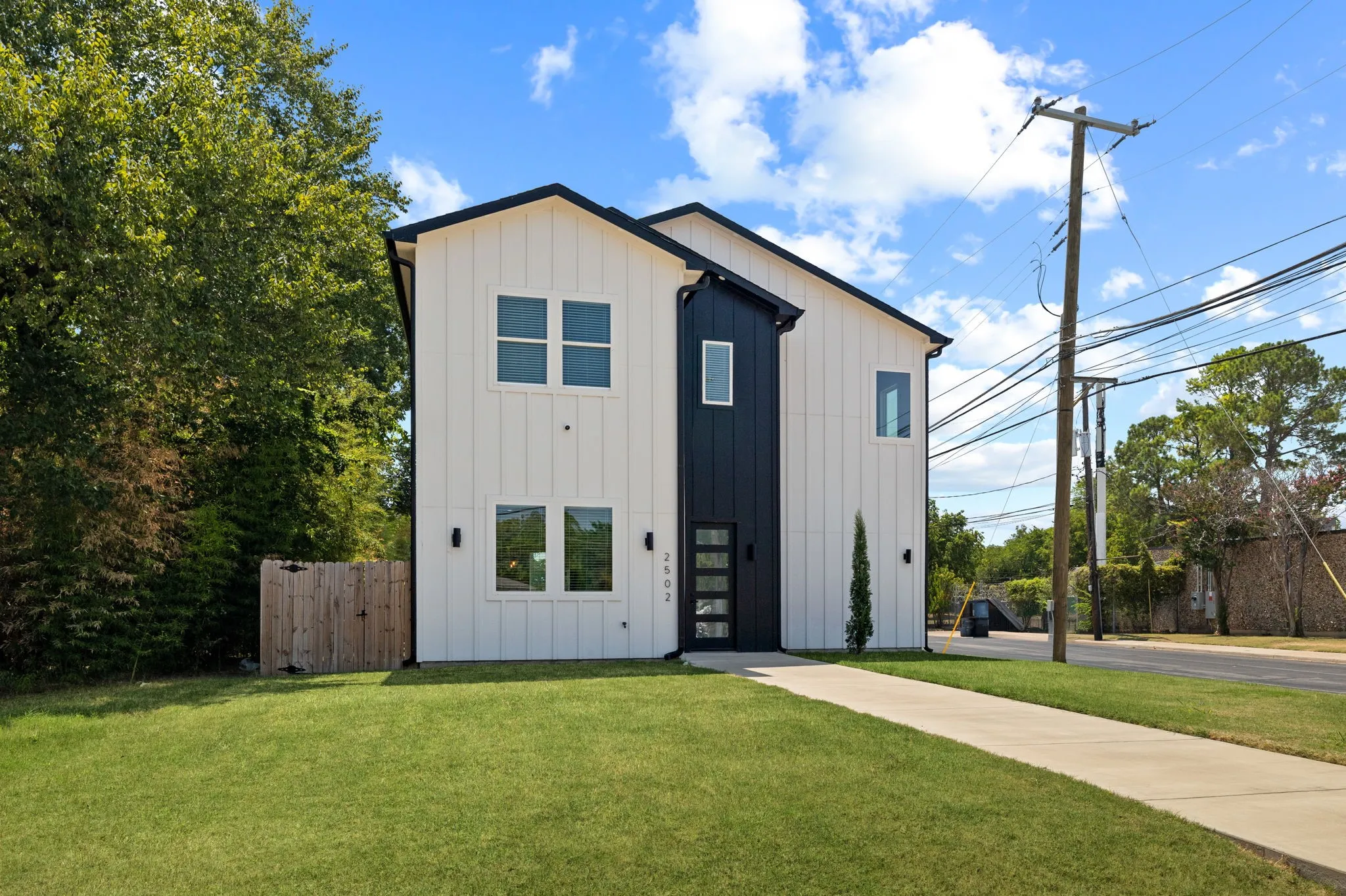 Modern farmhouse design with striking two-story architecture featuring a clean-lined facade in light and dark metal siding