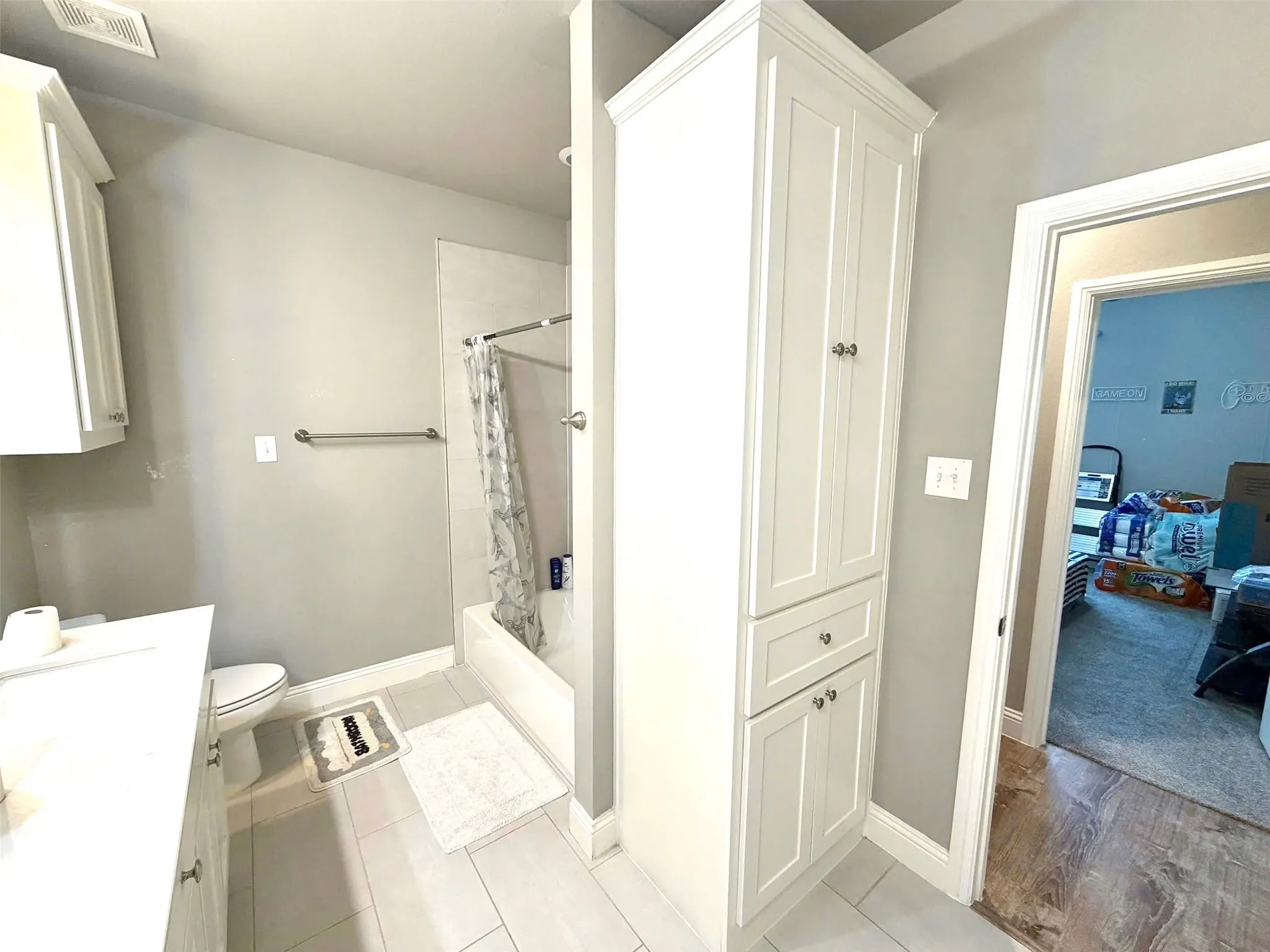 Bathroom featuring a full-size bathtub with shower, white subway tile surround, and a chrome shower rod