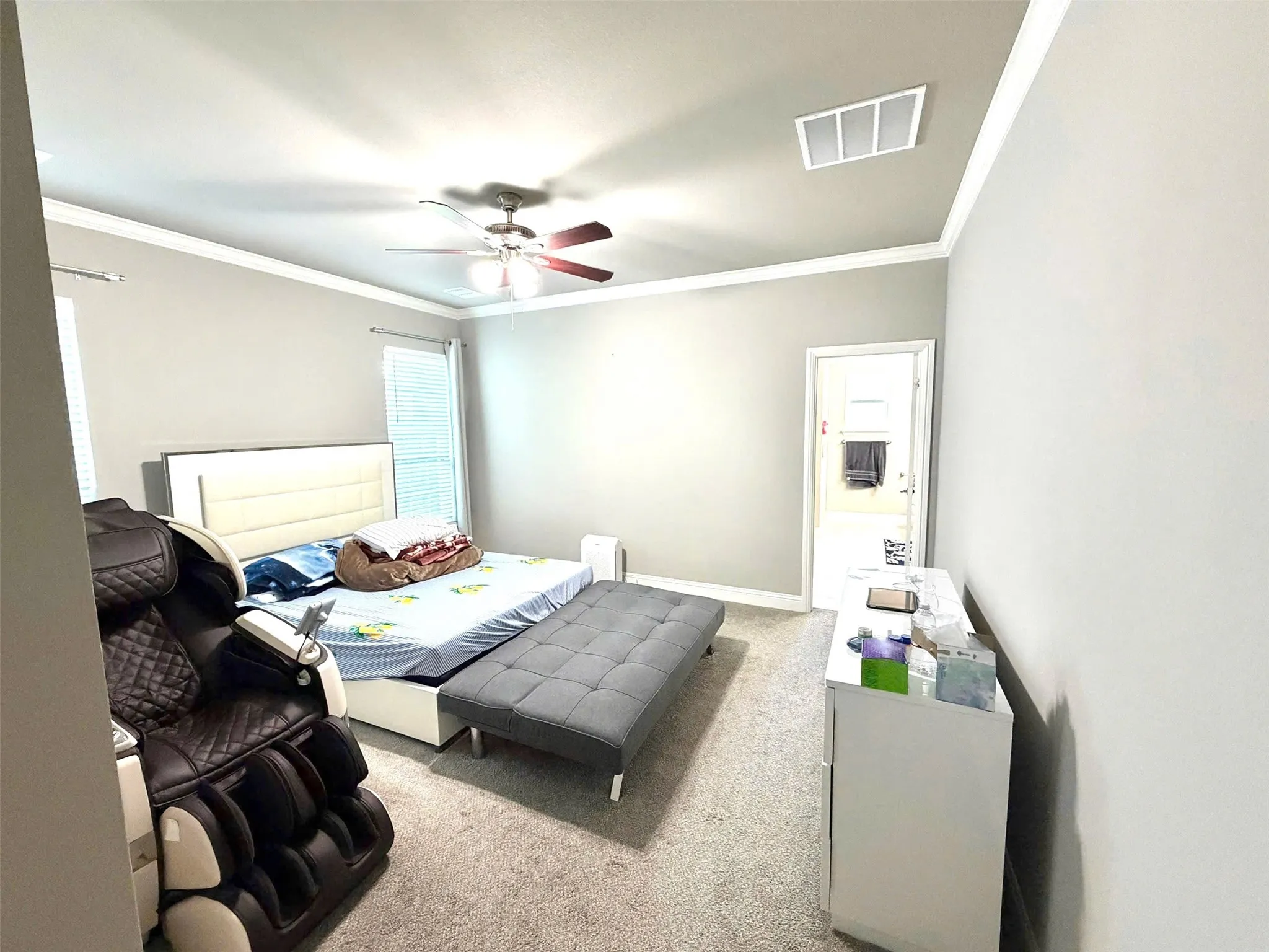 Spacious primary bedroom featuring neutral wall finishes, recessed ceiling lighting with ceiling fan, and carpeted flooring