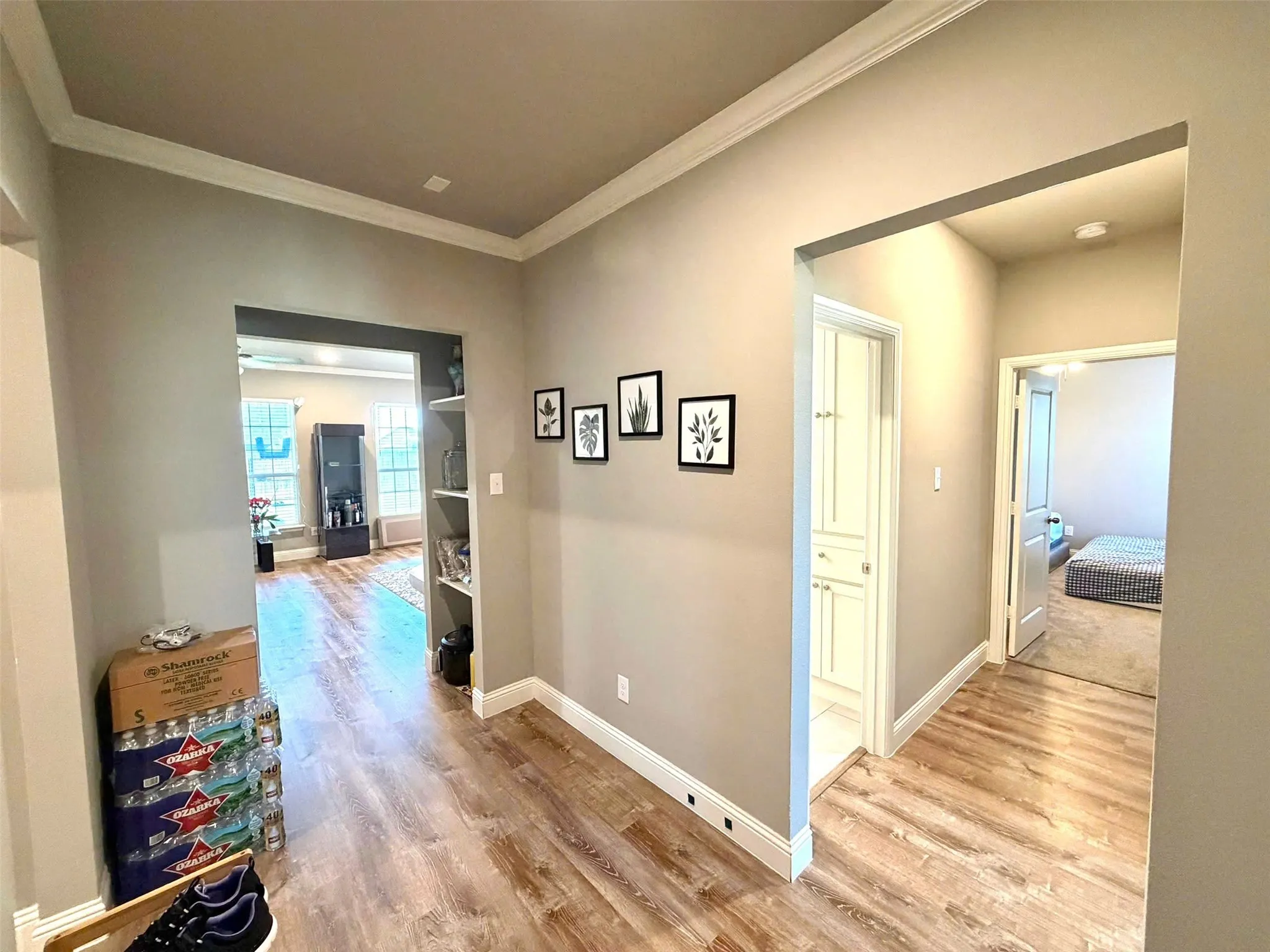 Bright hallway featuring wood-finish flooring throughout, neutral wall finishes, and recessed ceiling lighting