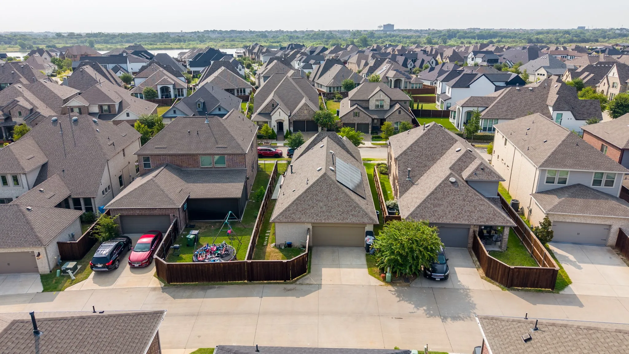 Aerial perspective of a suburban neighborhood featuring numerous single-family homes with pitched roofs