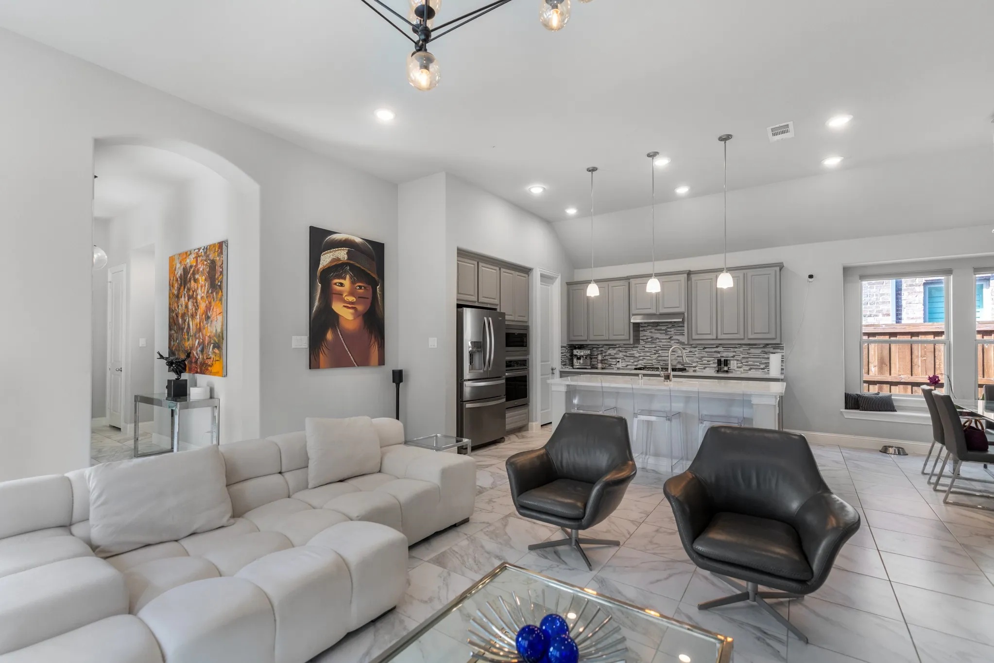 Open-concept living area featuring high vaulted ceilings, recessed lighting, and large format porcelain tile flooring