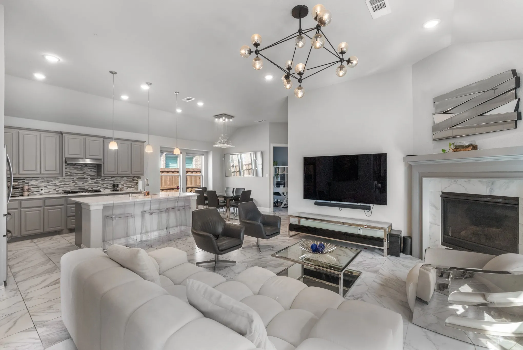 Open-concept living area featuring a vaulted ceiling and a contemporary chandelier